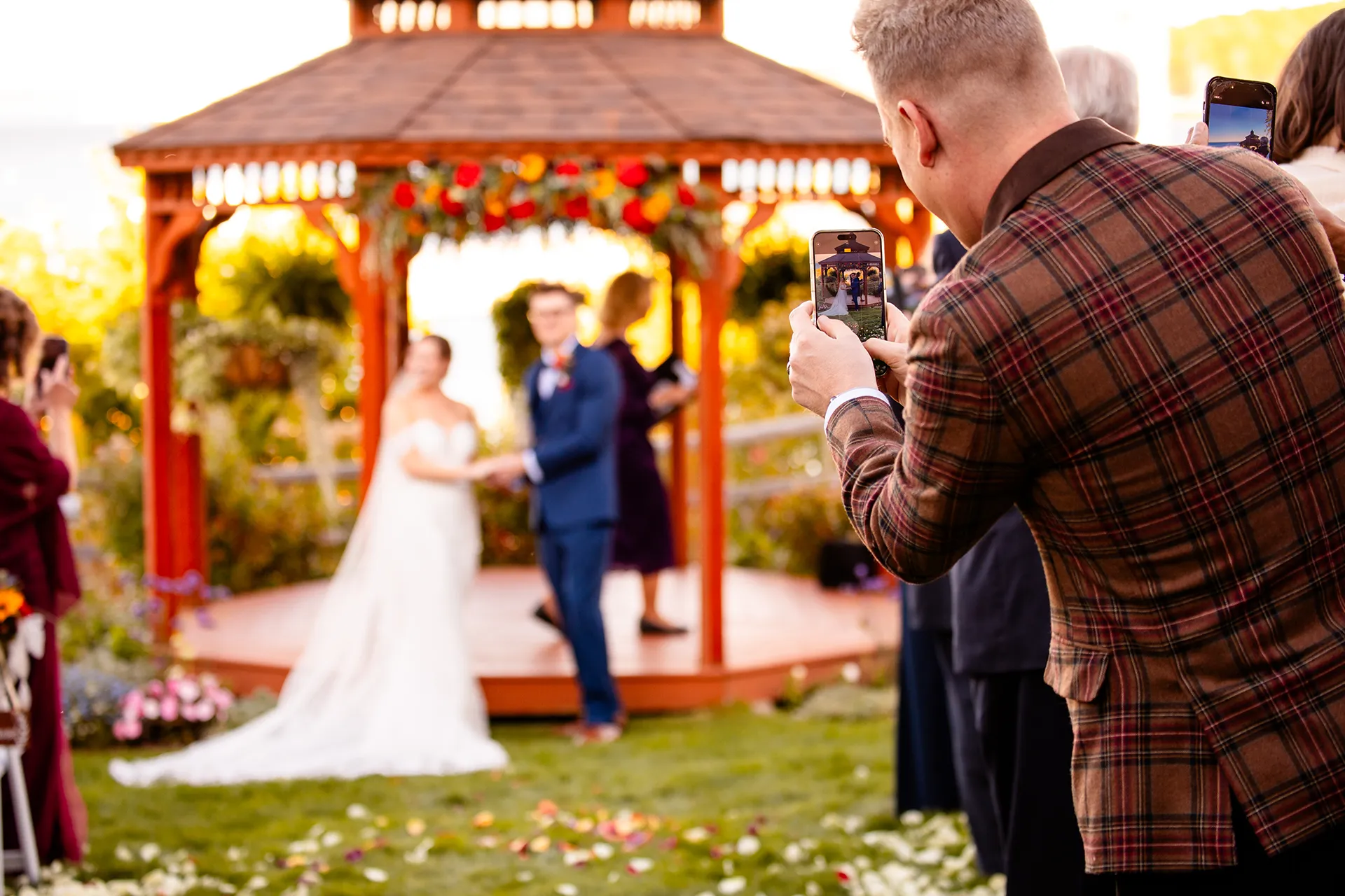 Guest takes a picture of the bride and groom during a wedding ceremony at the Atlantic Oceanside Hotel & Event Center in Bar Harbor, Maine.
