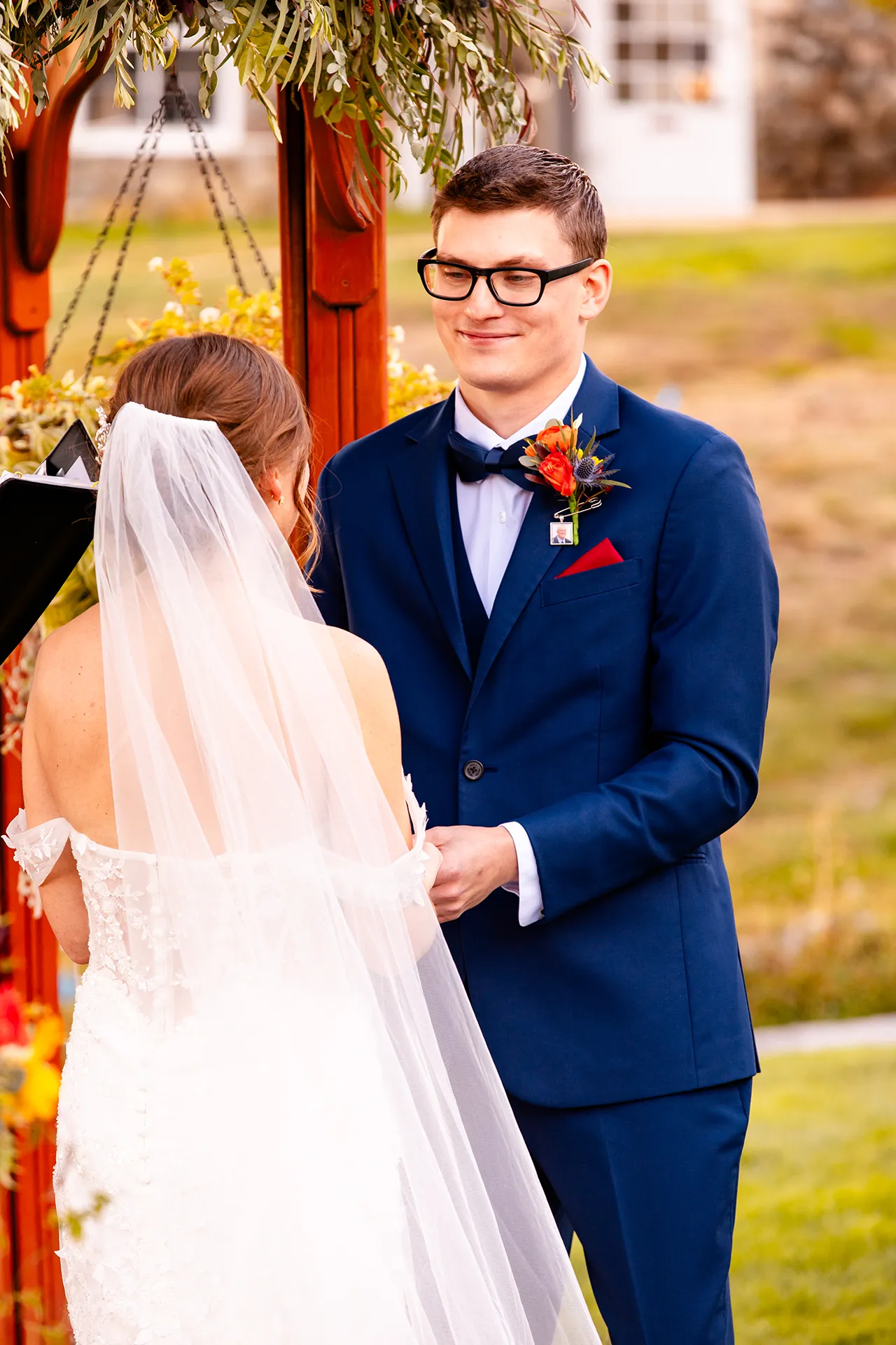 A groom holds a bride's hand and smiles during a wedding ceremony at the Atlantic Oceanside Hotel & Event Center in Bar Harbor, Maine.