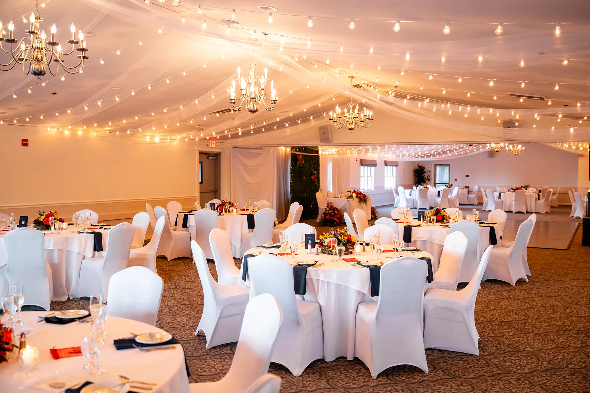 A wedding reception setup with colorful floral centerpieces at the Atlantic Oceanside Hotel & Event Center in Bar Harbor, Maine.