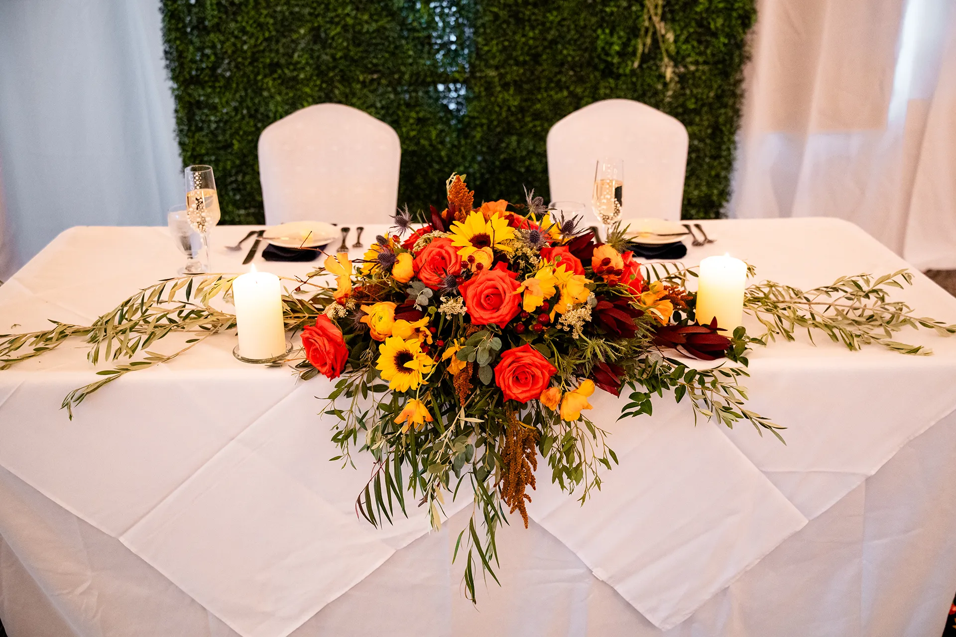A closeup of a red and yellow floral centerpiece for a wedding reception at the Atlantic Oceanside Hotel & Event Center in Bar Harbor, Maine.