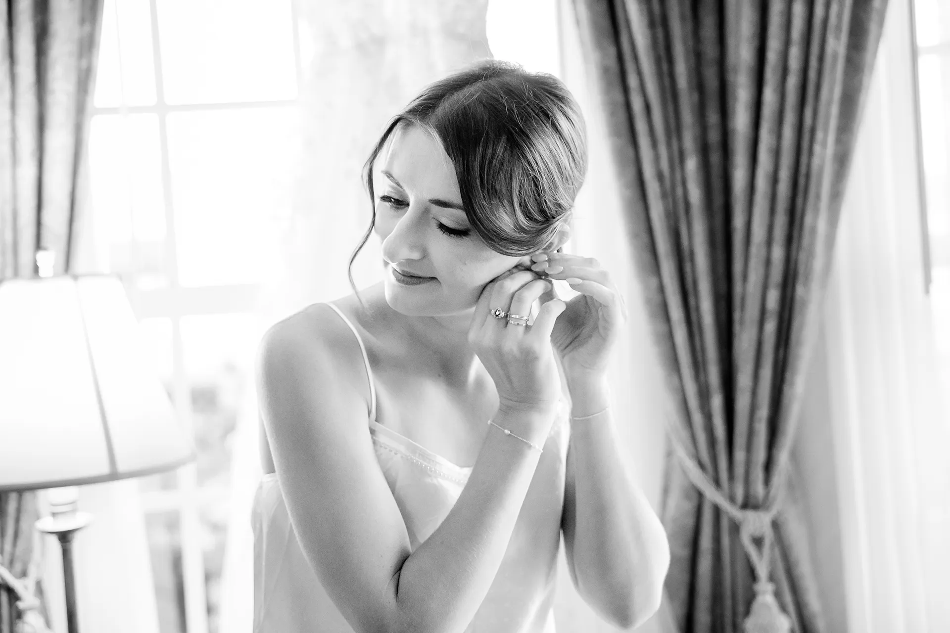 A bride puts on her earrings as she gets ready for a wedding at the Bar Harbor Inn and Spa near Acadia National Park in Maine.