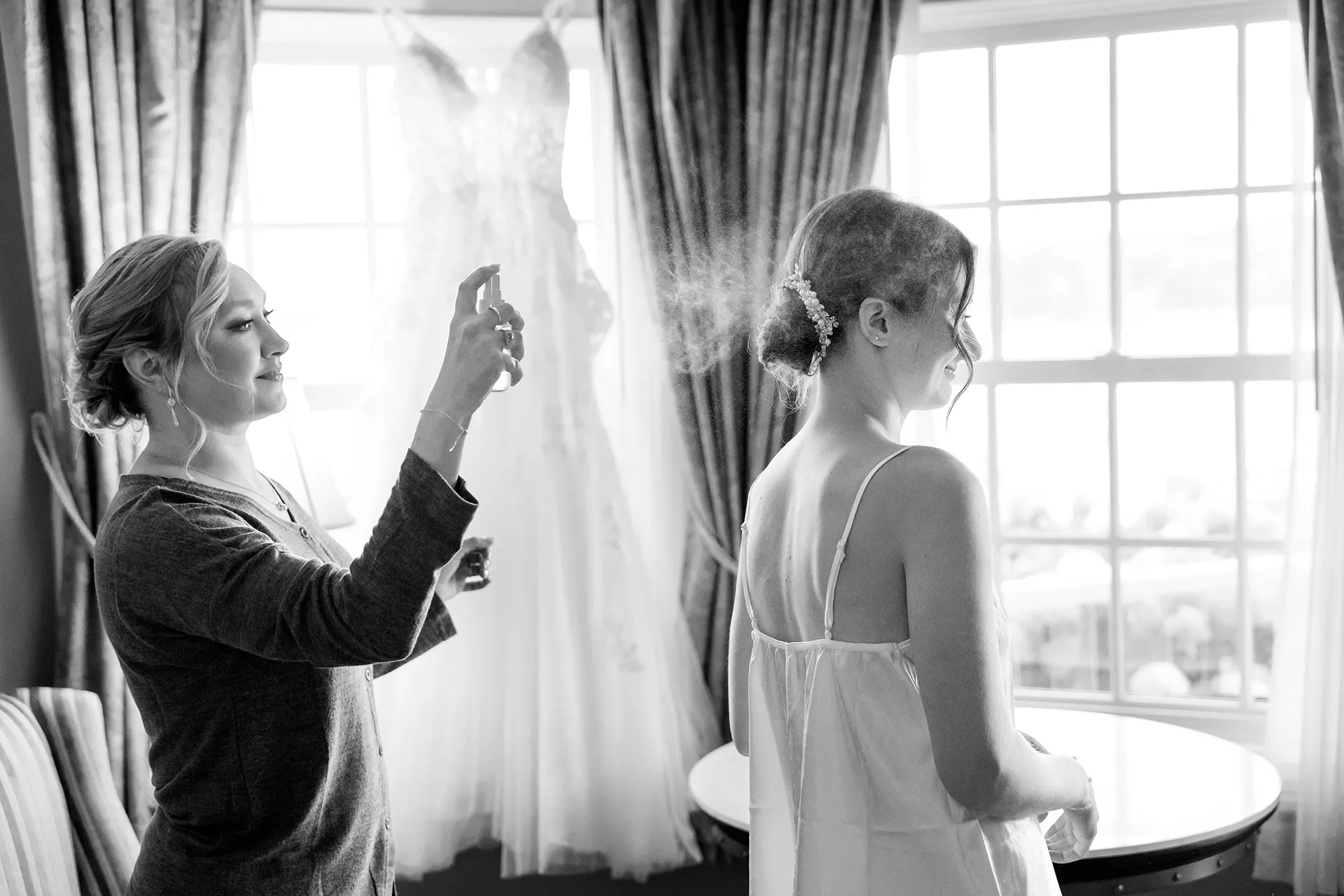 A bridesmaids sprays a bride's hair as she gets ready for a wedding at the Bar Harbor Inn and Spa near Acadia National Park in Maine.