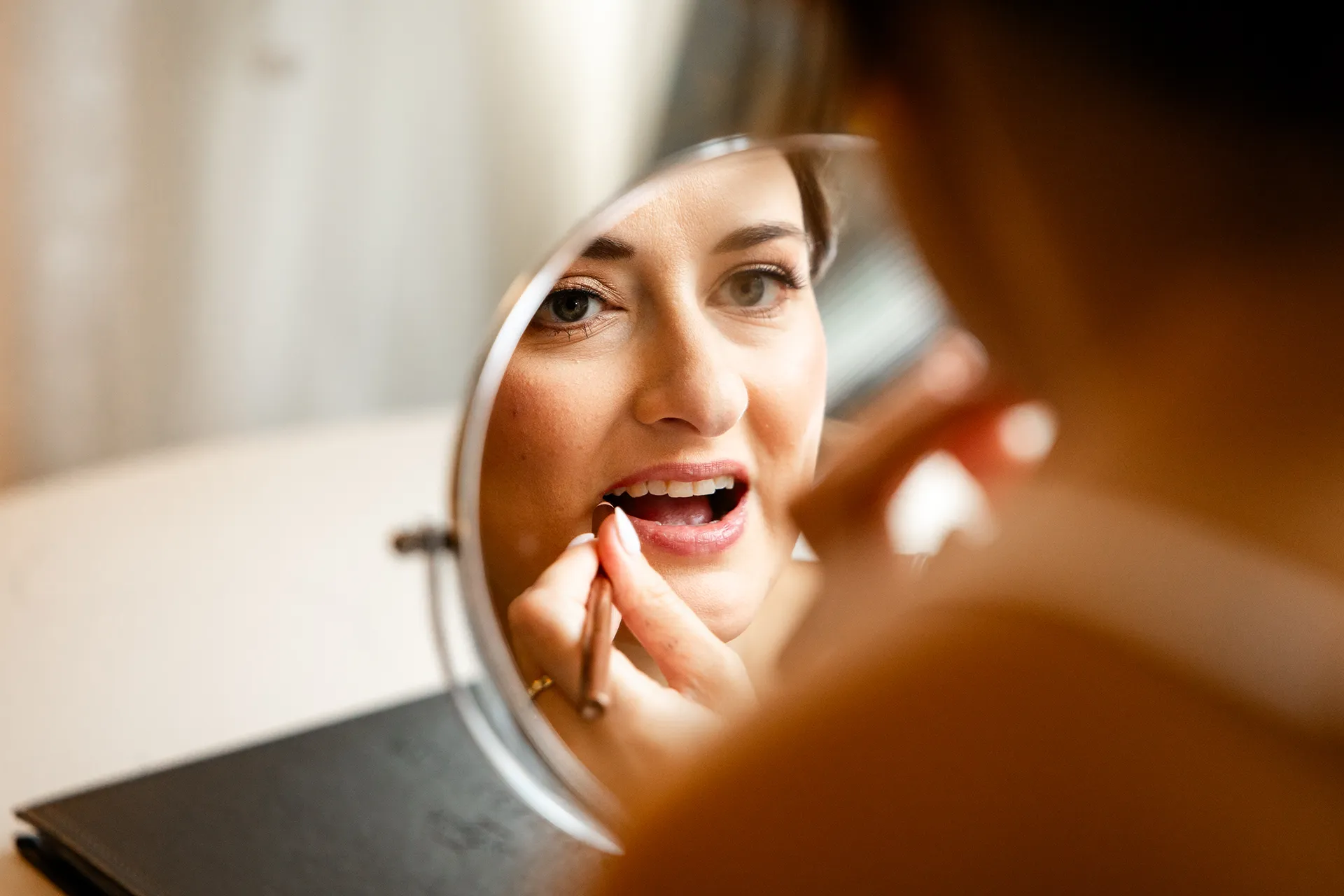 A bride puts on her lipstick as she gets ready for a wedding at the Bar Harbor Inn and Spa near Acadia National Park in Maine.