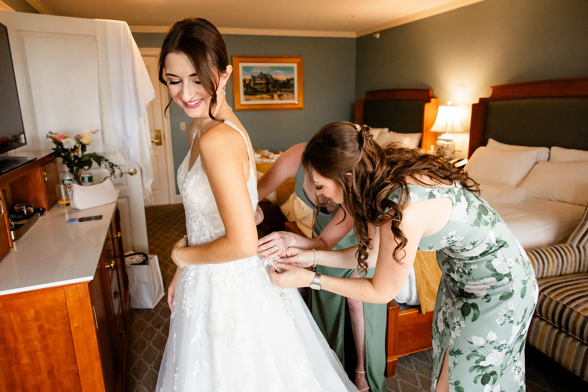 Bridesmaids help a bride with her dress as she gets ready for a wedding at the Bar Harbor Inn and Spa near Acadia National Park in Maine.