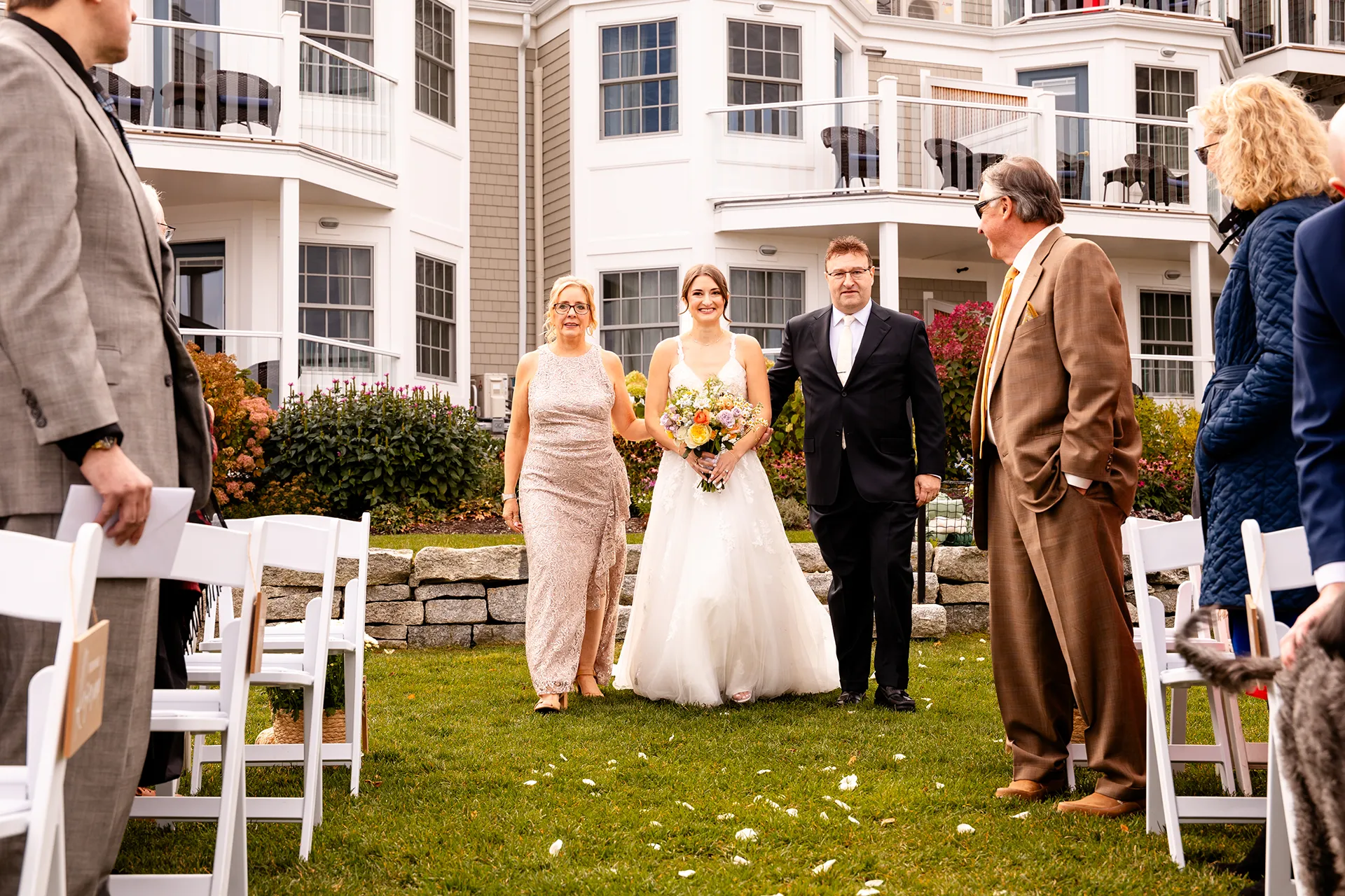 A bride and her parents walk down the aisle during a wedding ceremony at the Bar Harbor Inn and Spa near Acadia National Park in Maine.