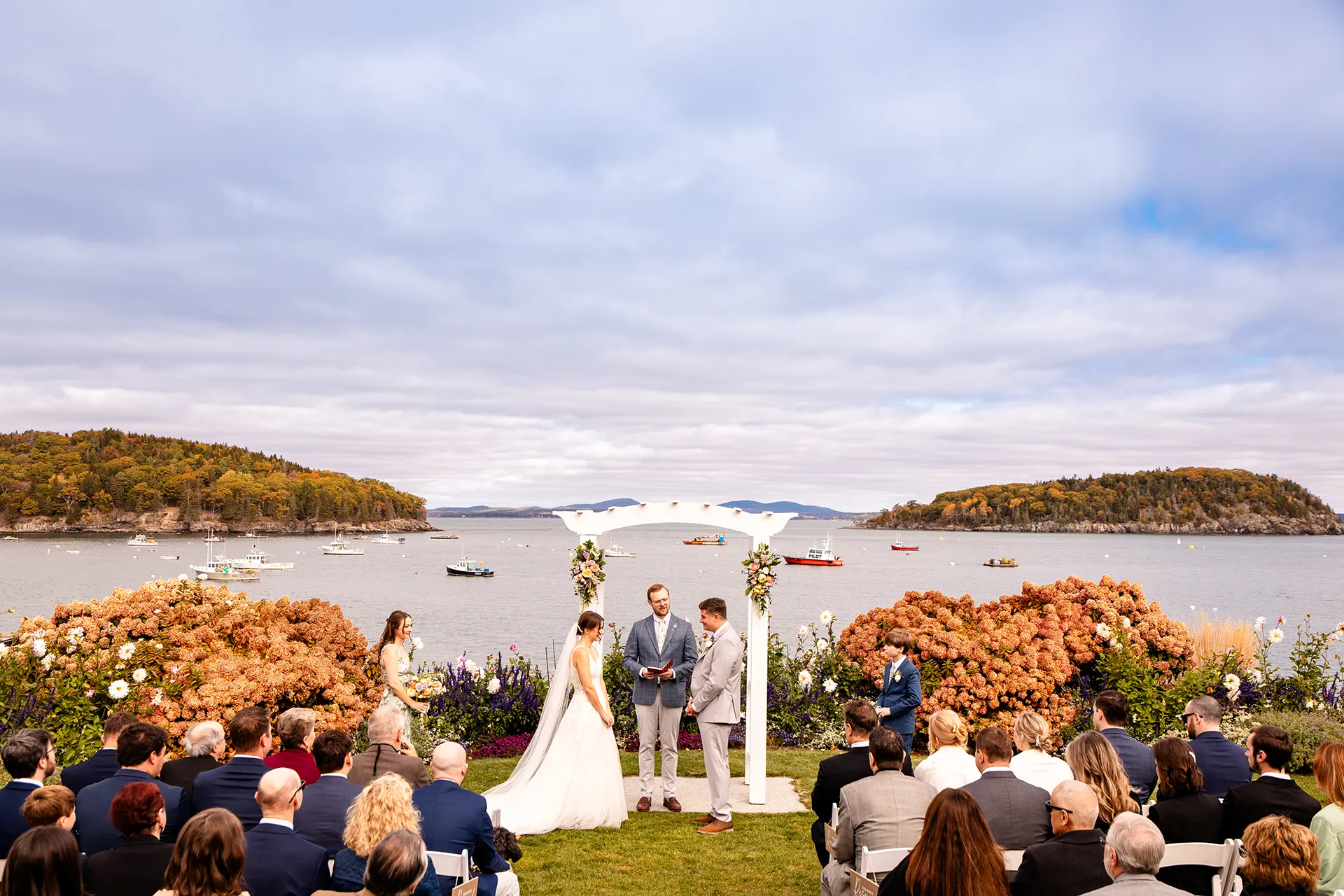 A couple stands in front of Frenchmans Bay during a wedding ceremony at the Bar Harbor Inn and Spa near Acadia National Park in Maine.