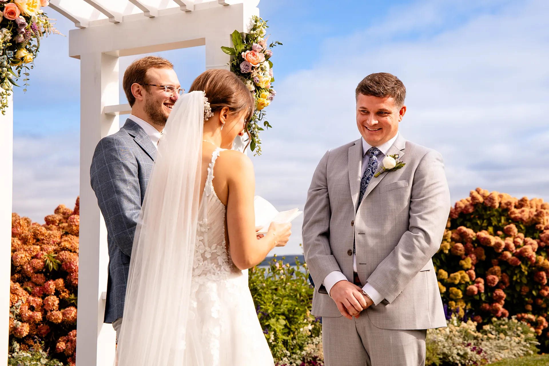 A groom smiles at a bride as she reads her vows during a wedding ceremony at the Bar Harbor Inn and Spa near Acadia National Park in Maine.