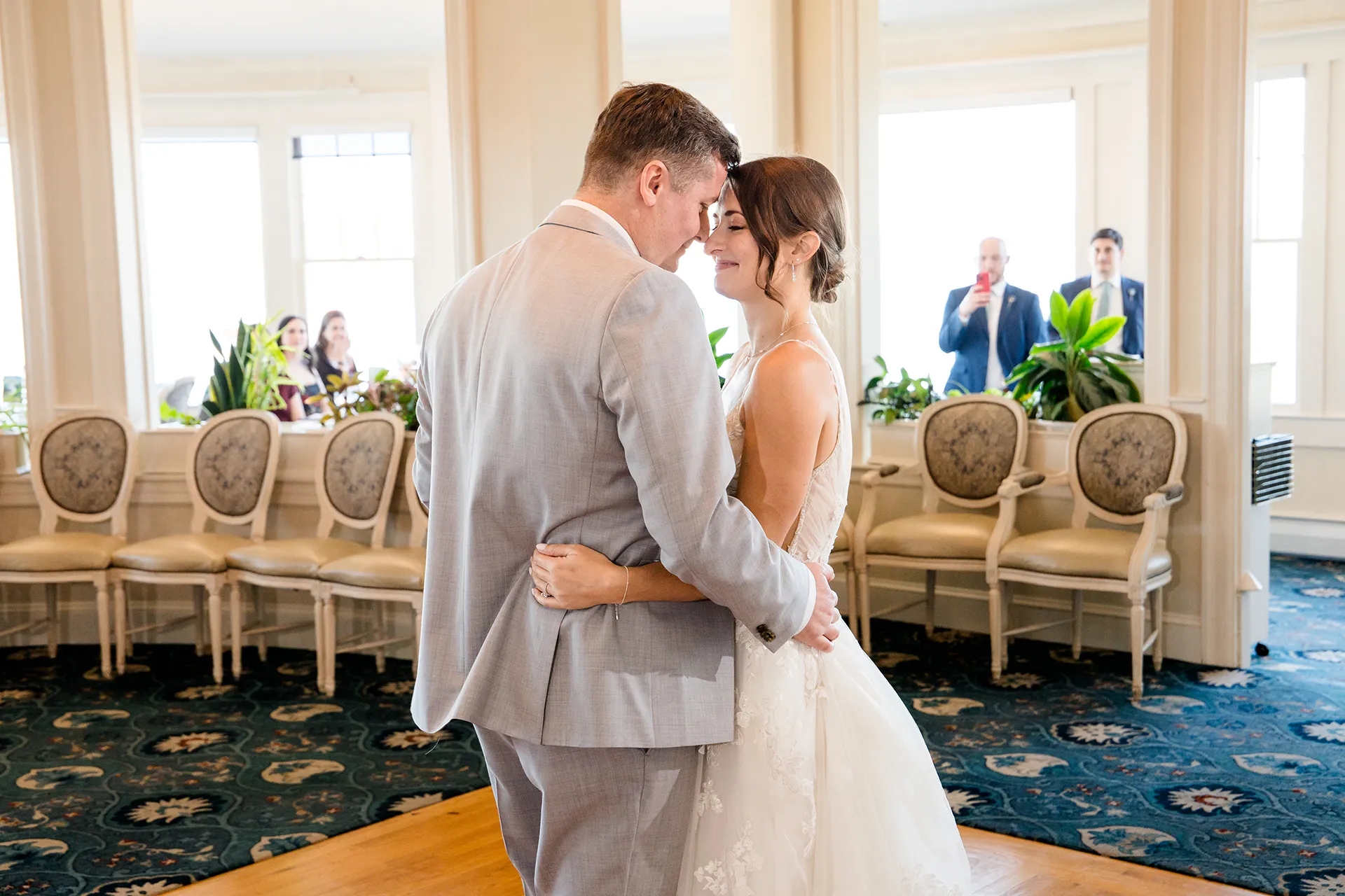 A bride and groom rest their heads together while they share a first dance during a wedding reception at the Bar Harbor Inn and Spa in Maine.