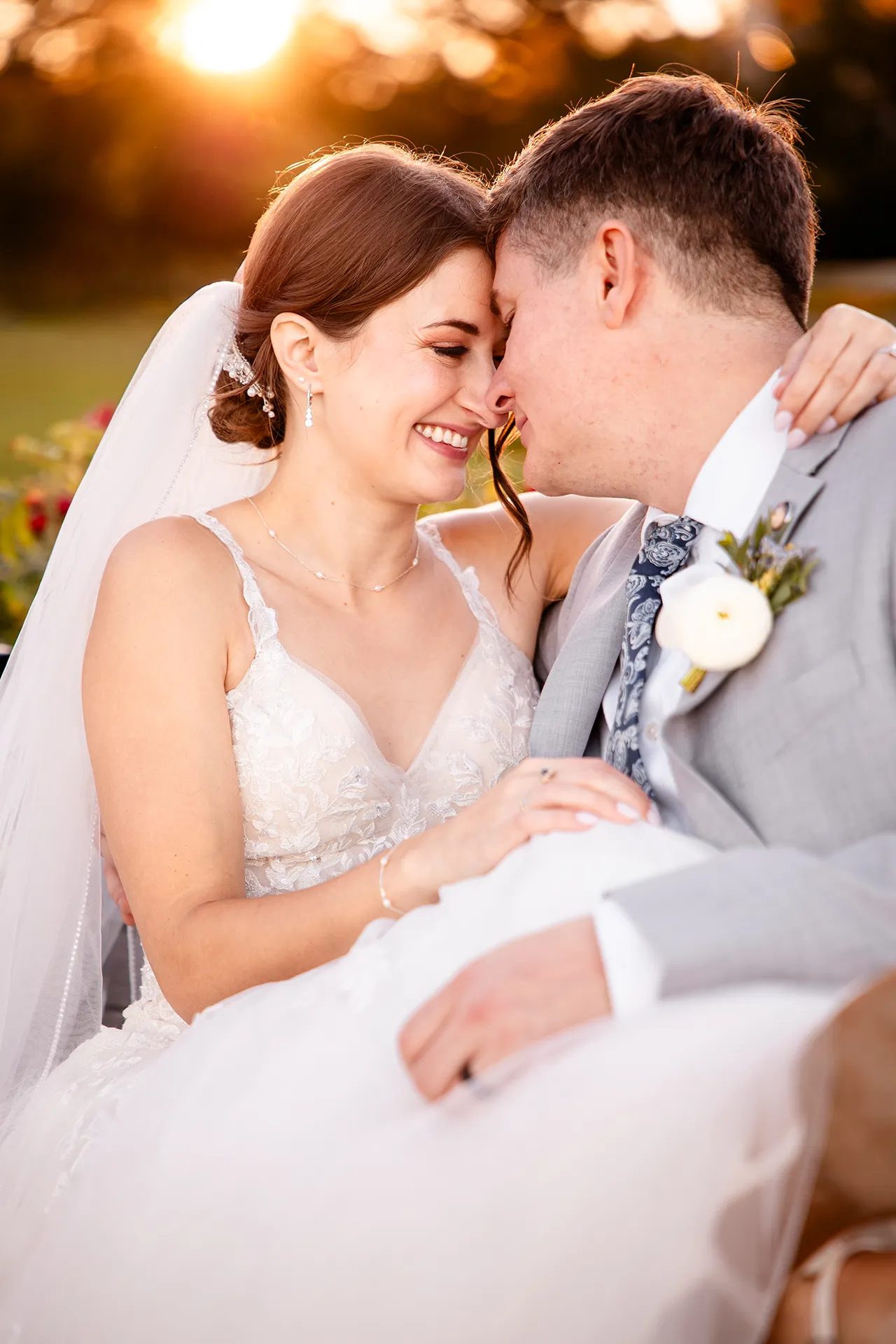 A bride and groom smile as they rest their heads together during wedding portraits near the Bar Harbor Inn and Spa in Maine.