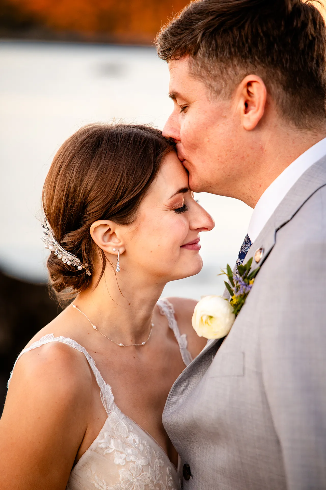 A groom kissed a bride on the head during wedding portraits at the Bar Harbor Inn and Spa near the Acadia National Park in Maine.