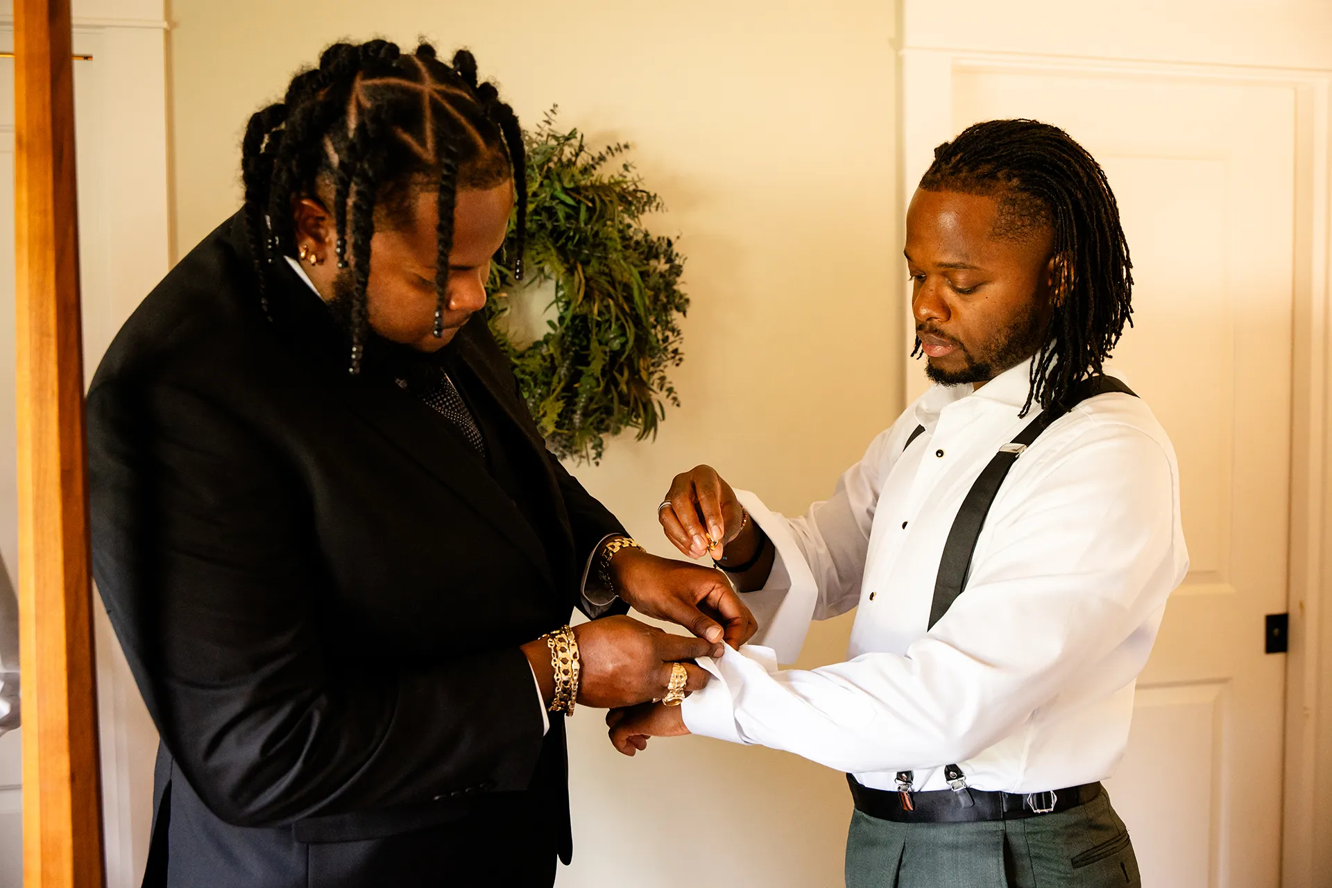 A man helps a groom put on his cufflinks as he gets ready for a wedding in Bangor, Maine.