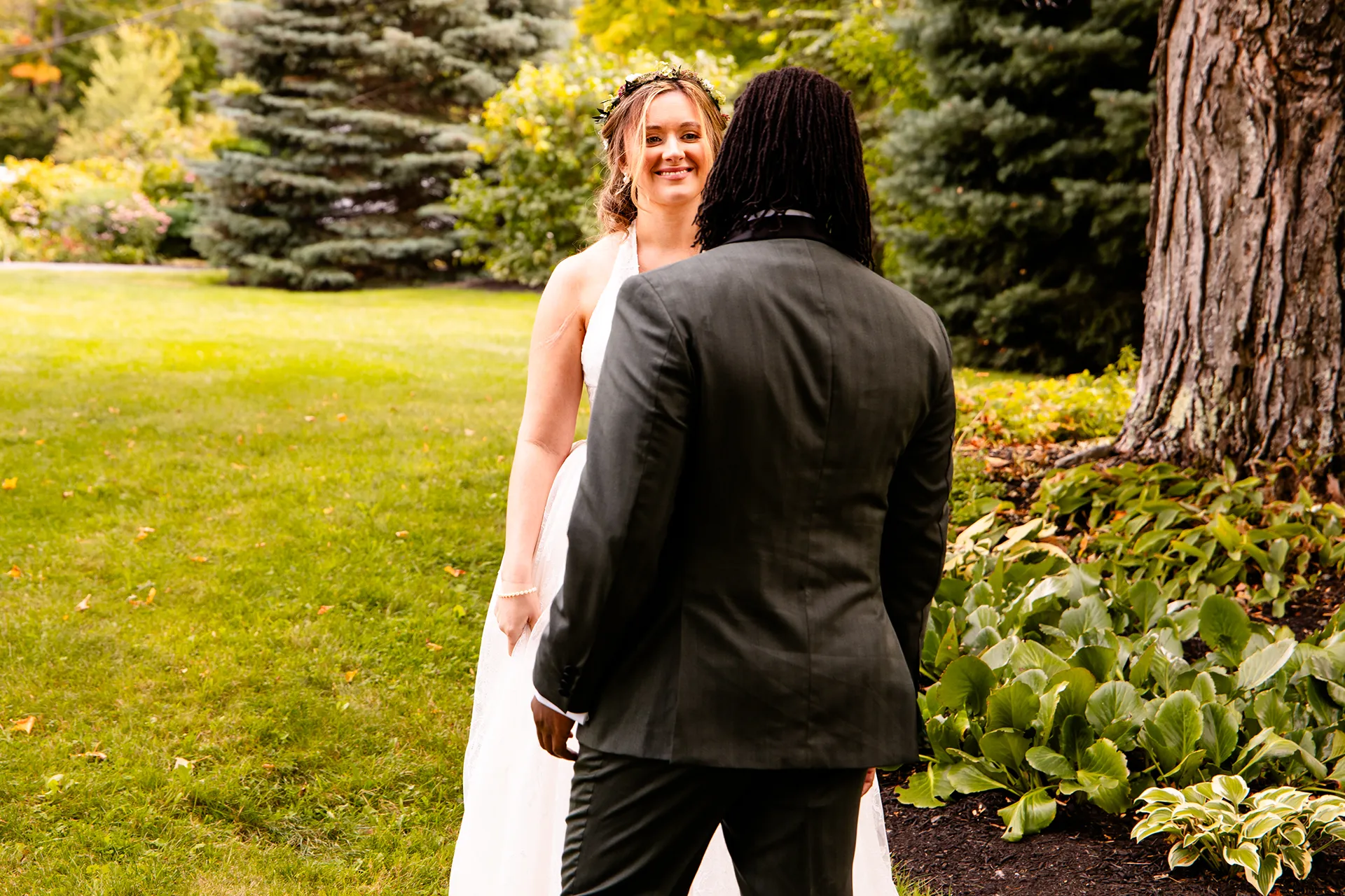 A bride smiles at at a groom after seeing him for the first time during a first look in Bangor, Maine.