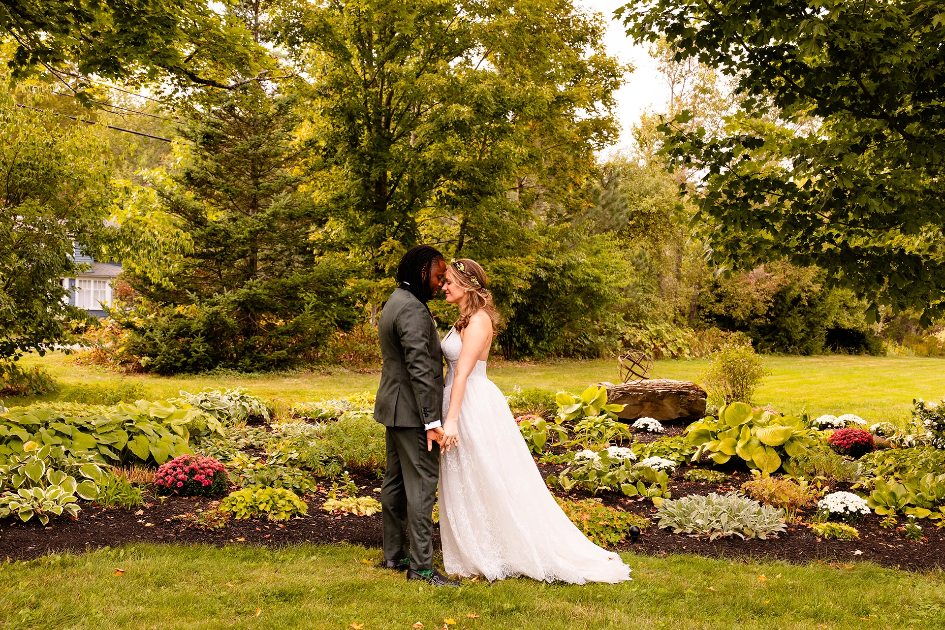 A bride and groom rest their front heads during wedding portraits in a garden at a private residence in Bangor, Maine.