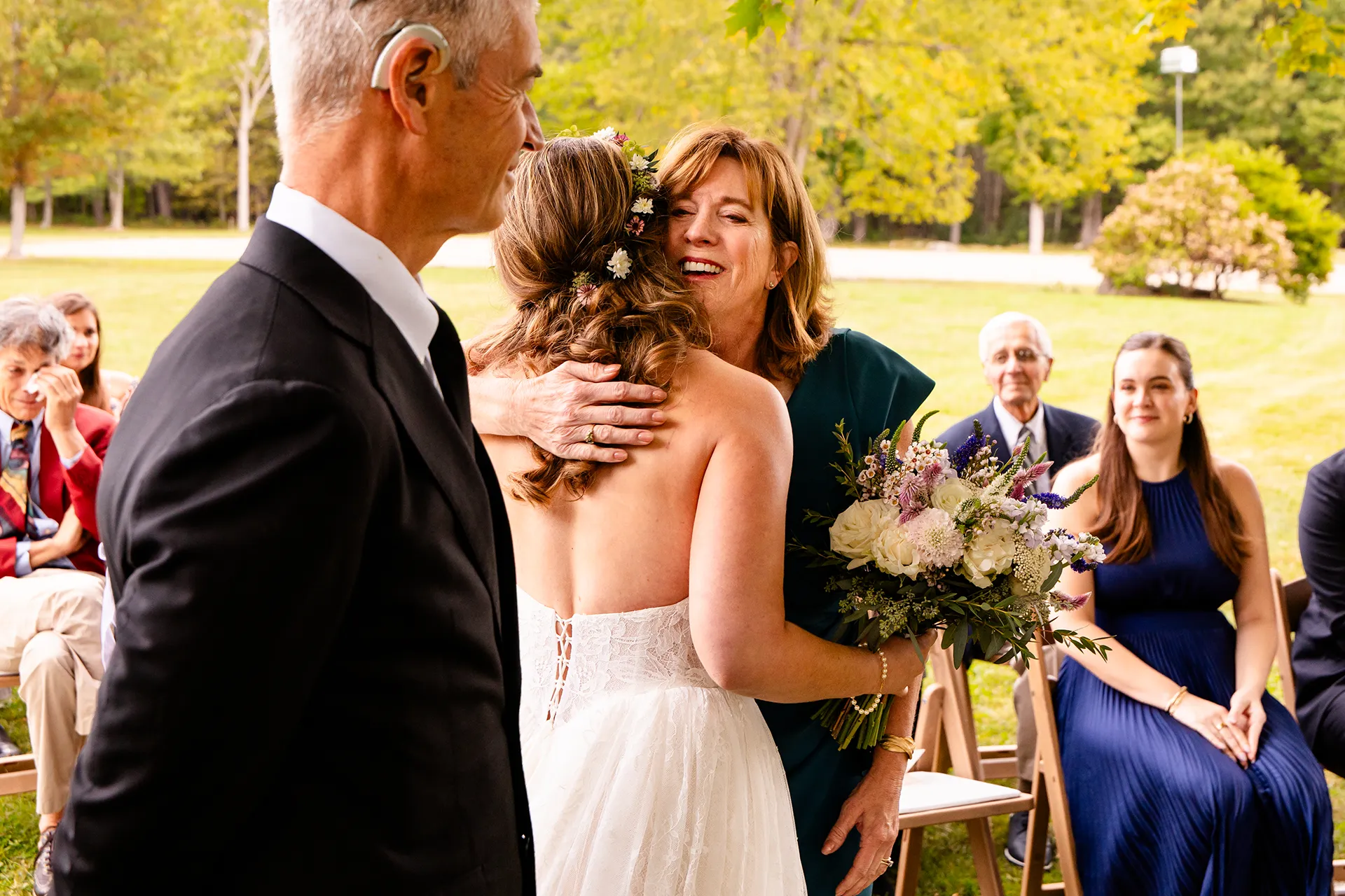 A mom smiles as she hugs a bride during a wedding ceremony in Bangor, Maine.