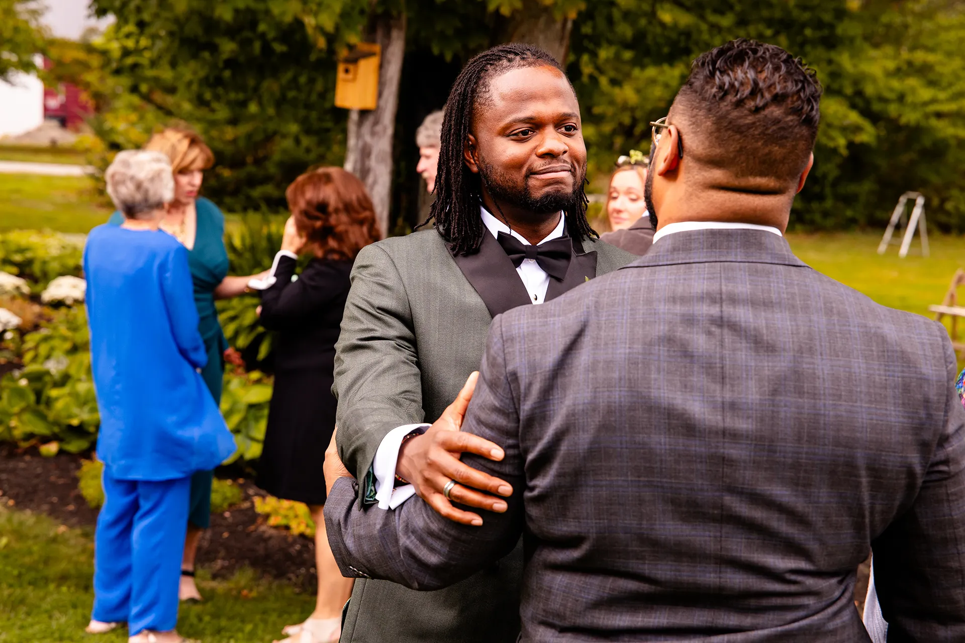 A groom smiles at a guests after a wedding ceremony in Bangor, Maine.