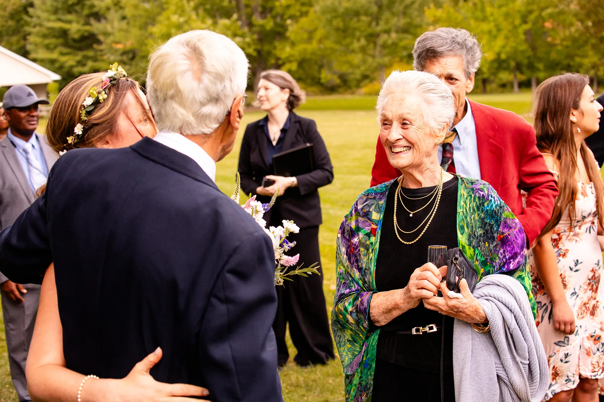 A grandmother smiles at a bride as she hugs a grandfather after a wedding ceremony in Bangor, Maine.
