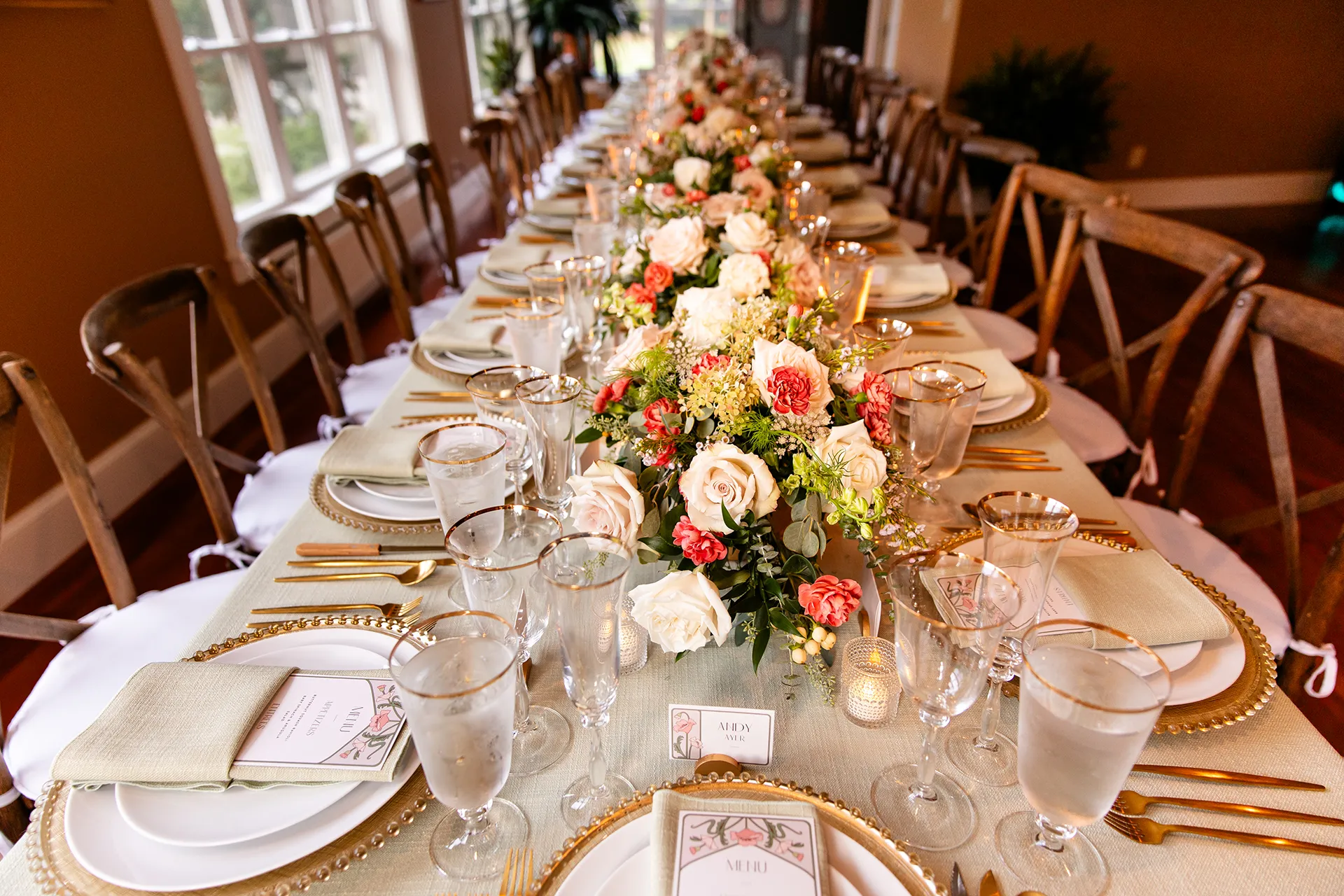 A closeup of several pink and read floral centerpieces for a wedding reception in Bangor, Maine.