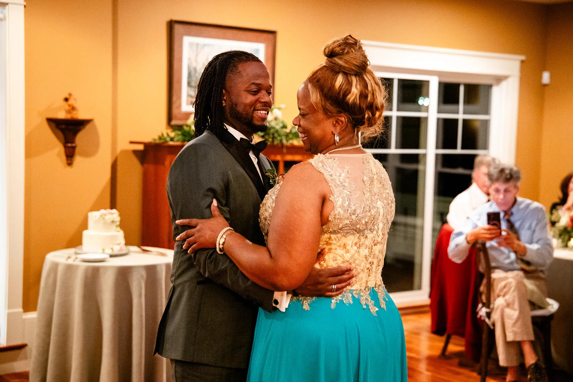 A groom and his mom laugh as they during a micro wedding reception at a private residence in Bangor, Maine.