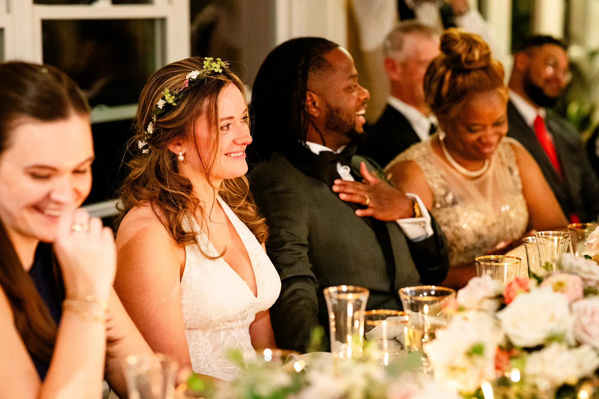 A bride and groom laugh as they listen to a toast during a micro wedding reception at a private residence in Bangor, Maine.