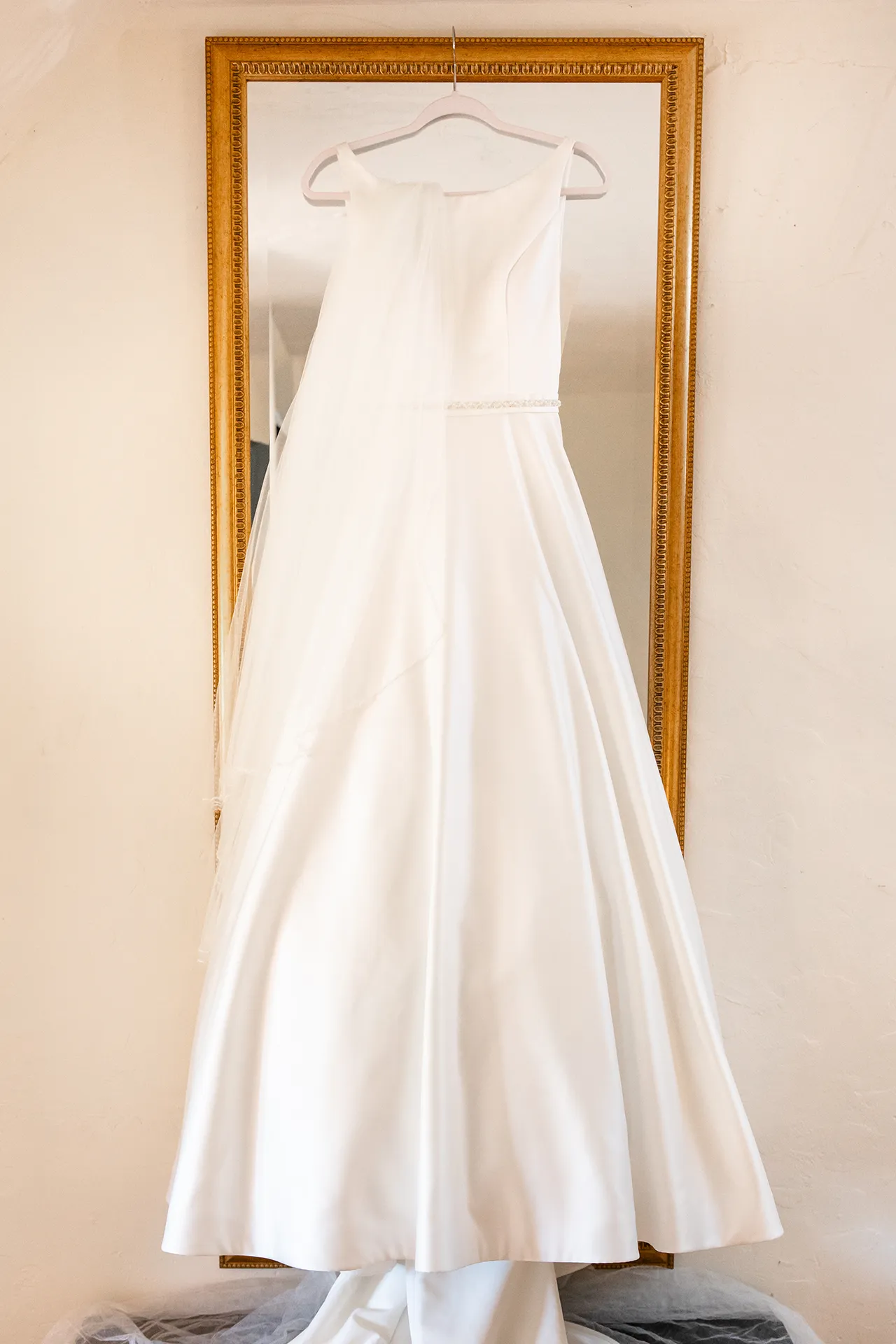 A white wedding dress hangs from a mirror at the Bar Harbor Club near Acadia National Park in Maine.
