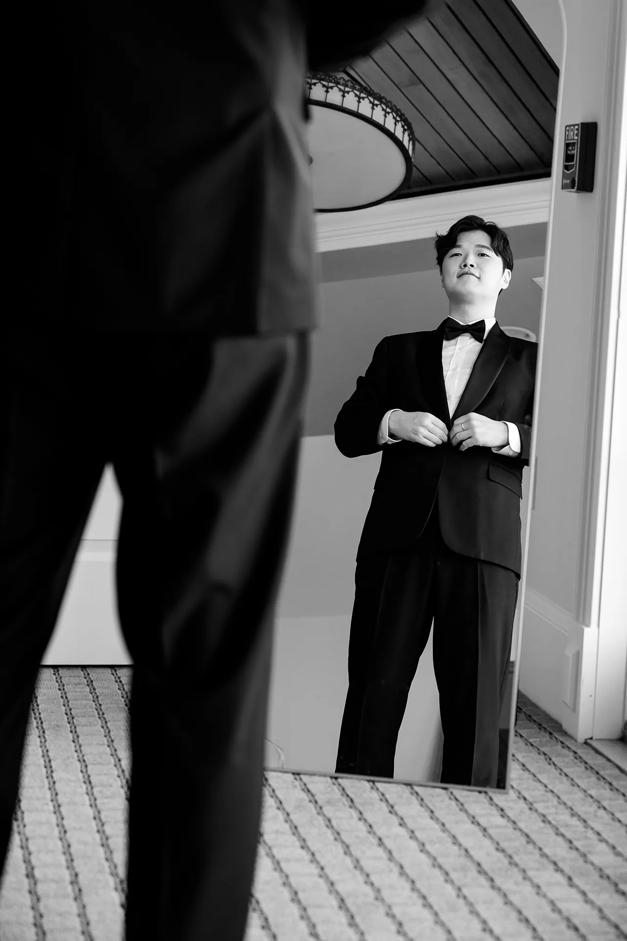 A groom buttons his suit jacket as he gets ready for a wedding at the Bar Harbor Club near Acadia National Park in Maine.