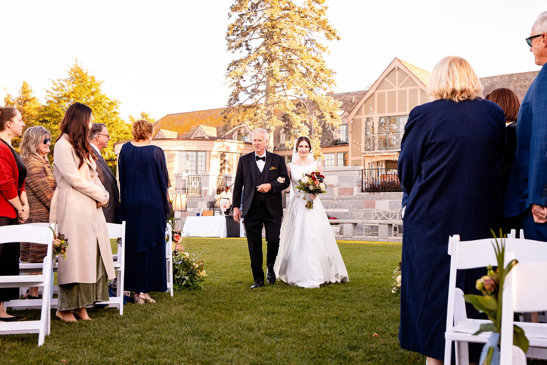 A bride and her dad walk down the aisle during a wedding ceremony at the Bar Harbor Club near Acadia National Park in Maine.