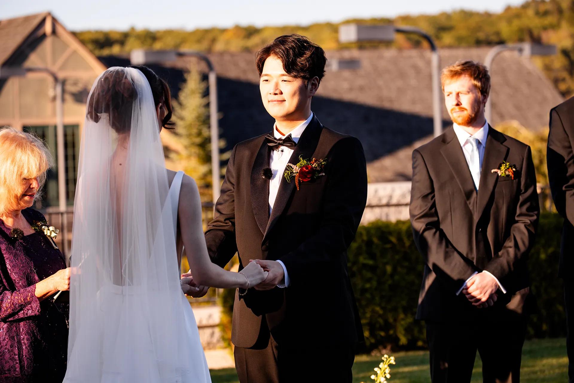 A groom smiles as he holds a bride's hands during a wedding ceremony at the Bar Harbor Club near Acadia National Park in Maine.