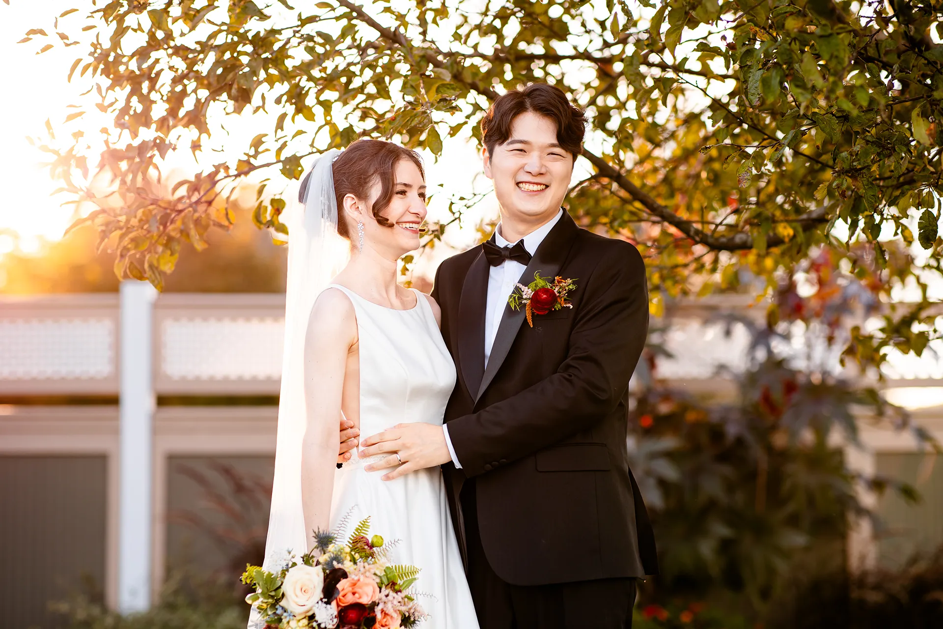 A bride and groom laugh during wedding portraits at the Bar Harbor Club near Acadia National Park in Maine.