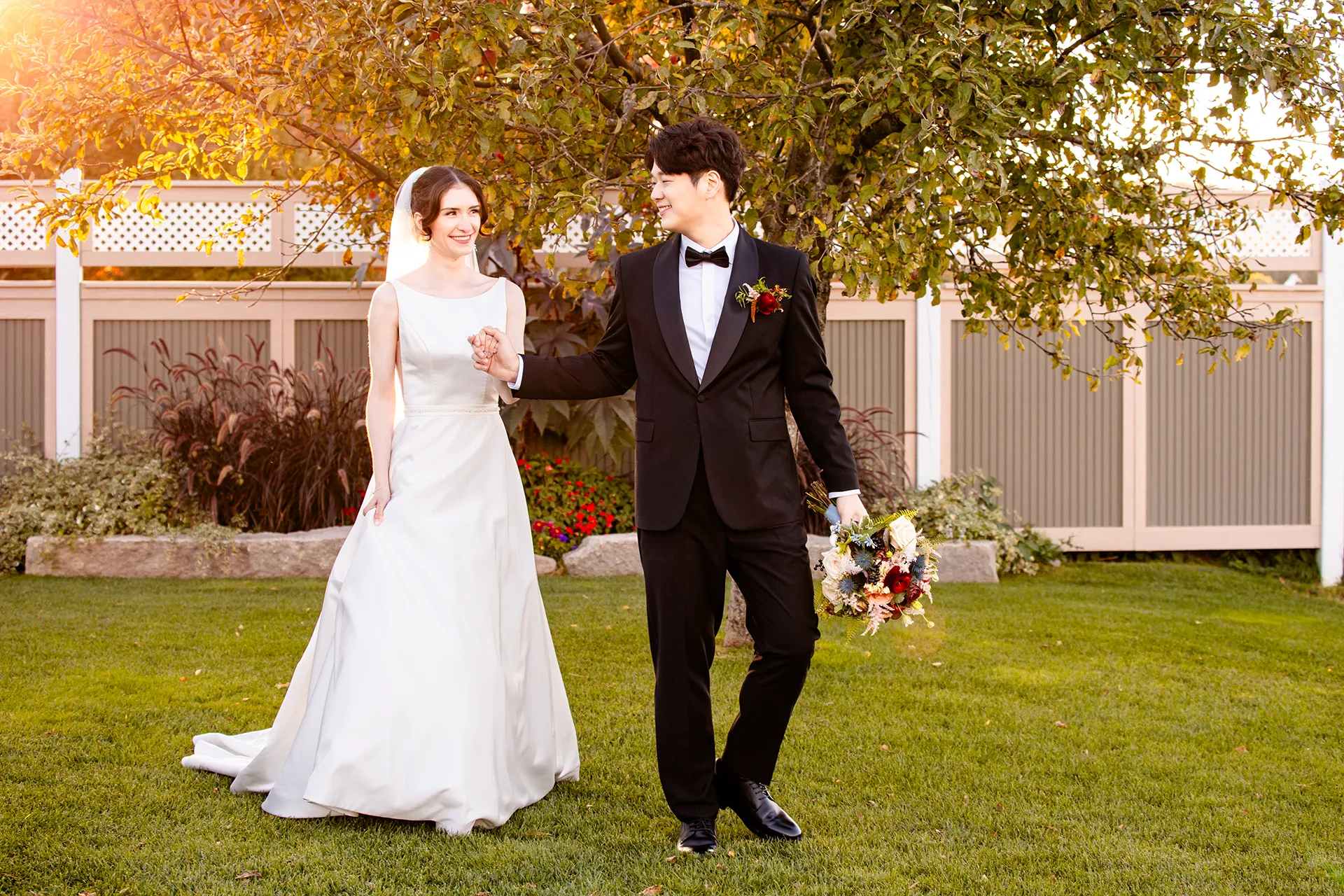 A bride and groom hold hands as they walk during wedding portraits at the Bar Harbor Club near Acadia National Park in Maine.