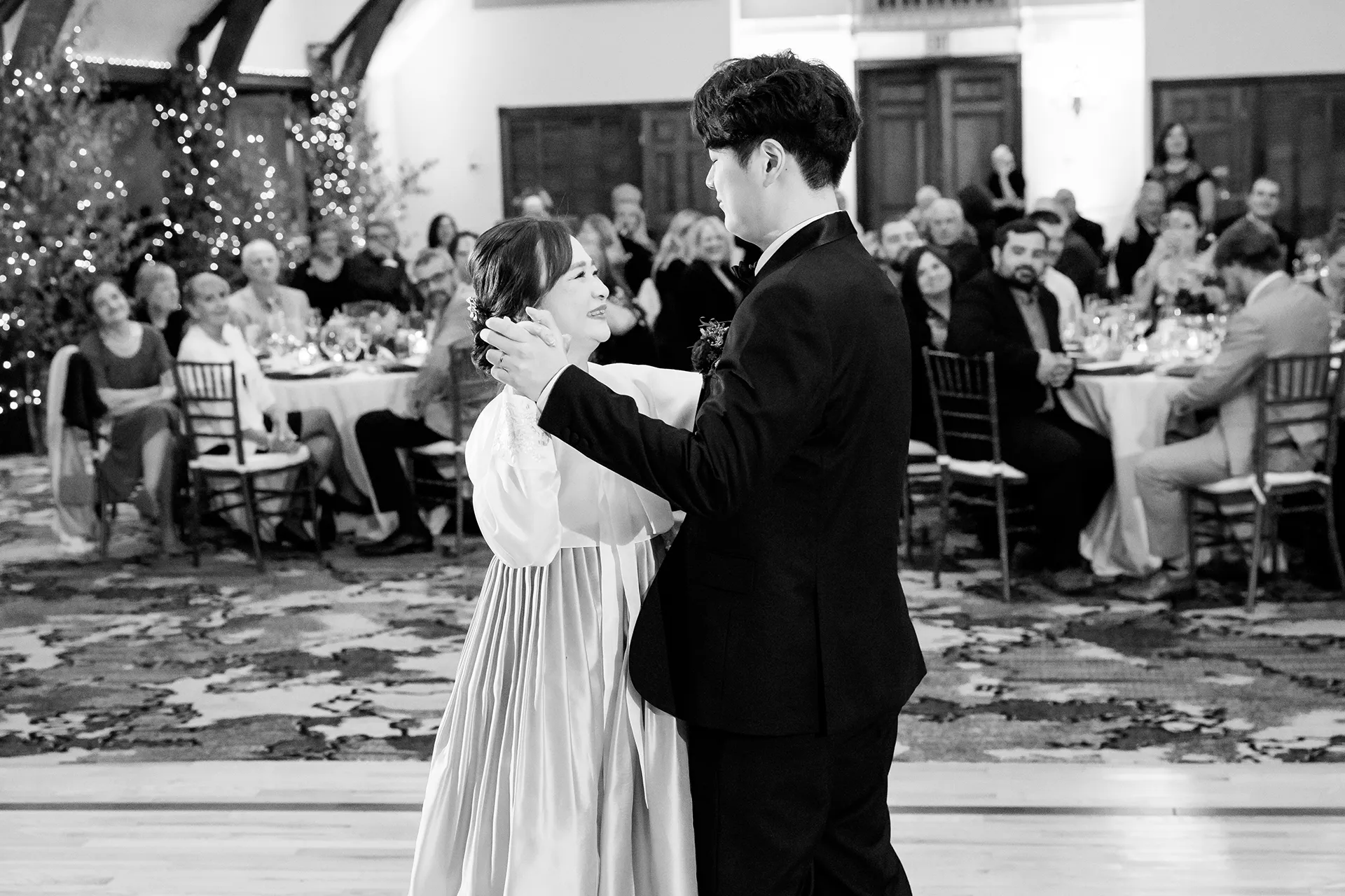 A mom smiles at a groom as they dance during a wedding reception at the Bar Harbor Club in Maine.