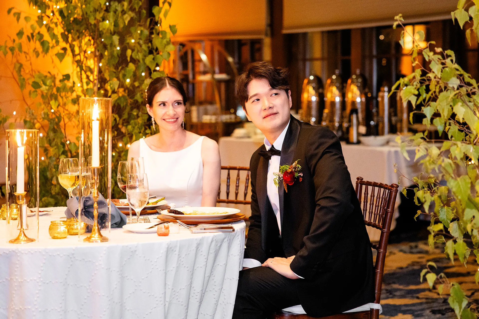 A bride and groom smile while listening to a toast during a wedding reception at the Bar Harbor Club in Maine.