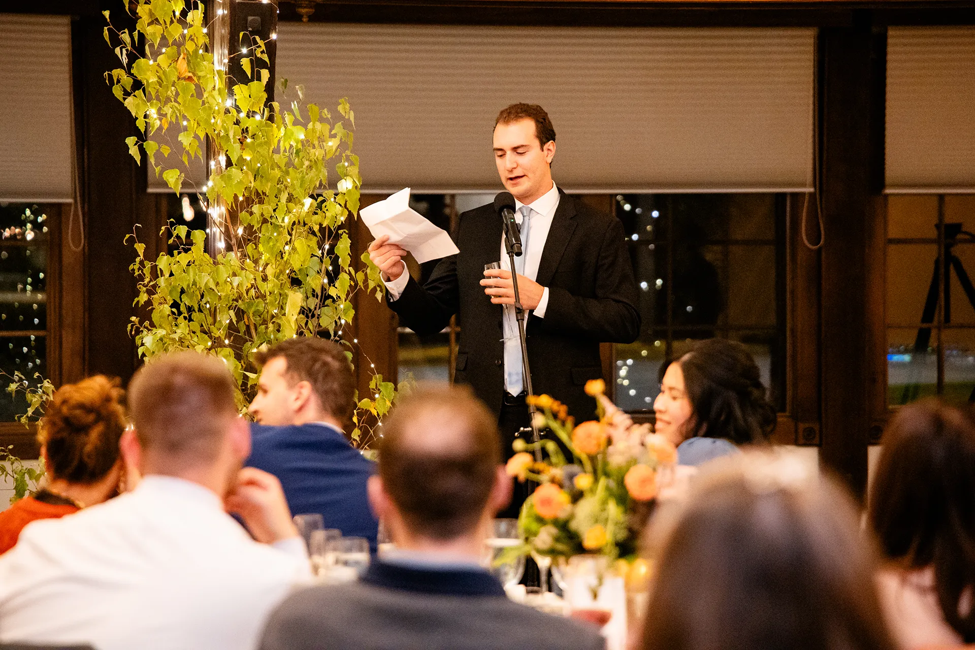 A groomsman gives a toast while guests listen during a wedding reception at the Bar Harbor Club in Maine.
