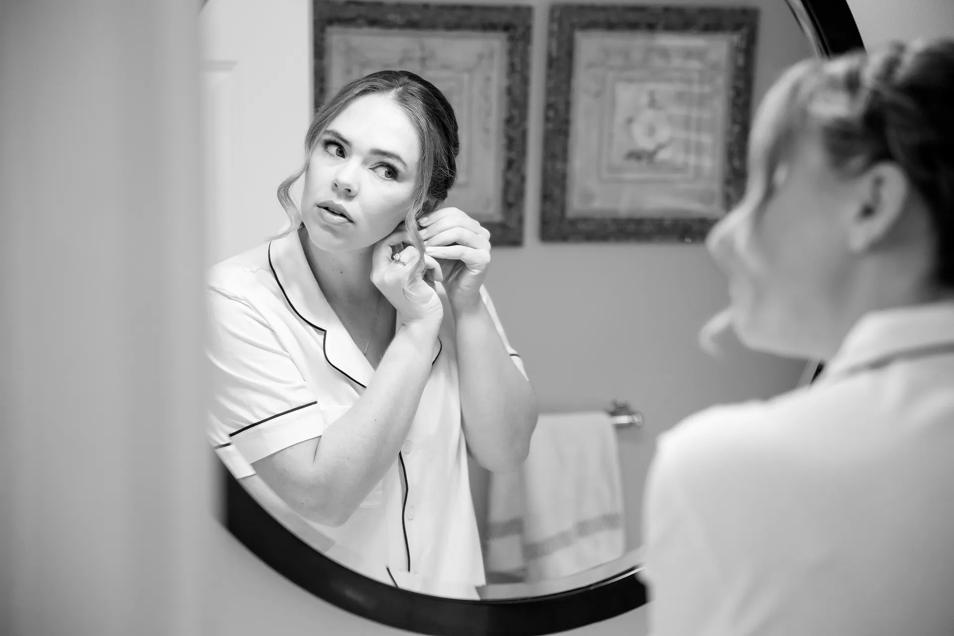A bride puts her earrings on as she get ready for a wedding at Fruitlands Museum in Harvard Massachusetts.