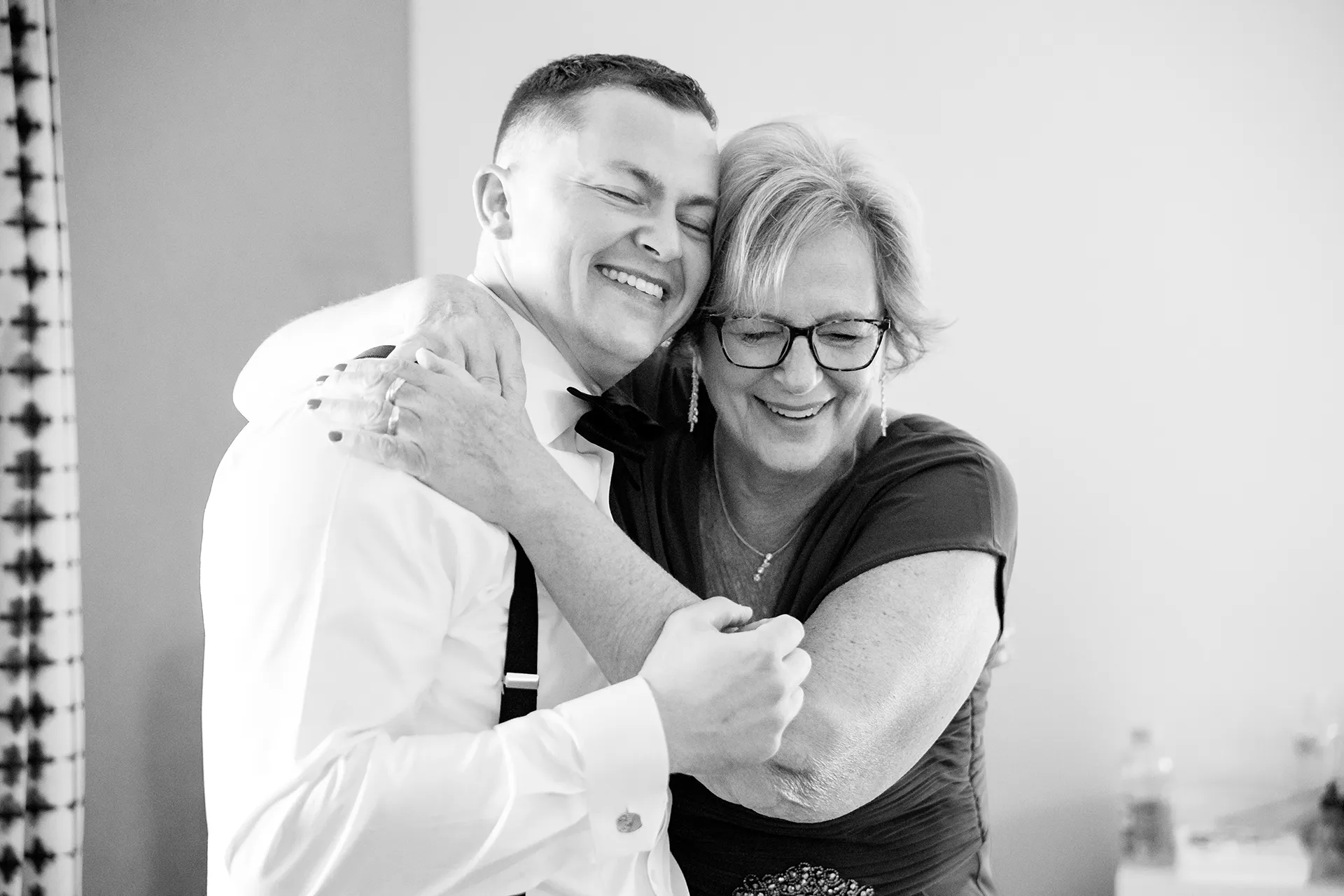 A mom hugs a groom as he gets ready for a wedding at Fruitlands Museum in Harvard Massachusetts.