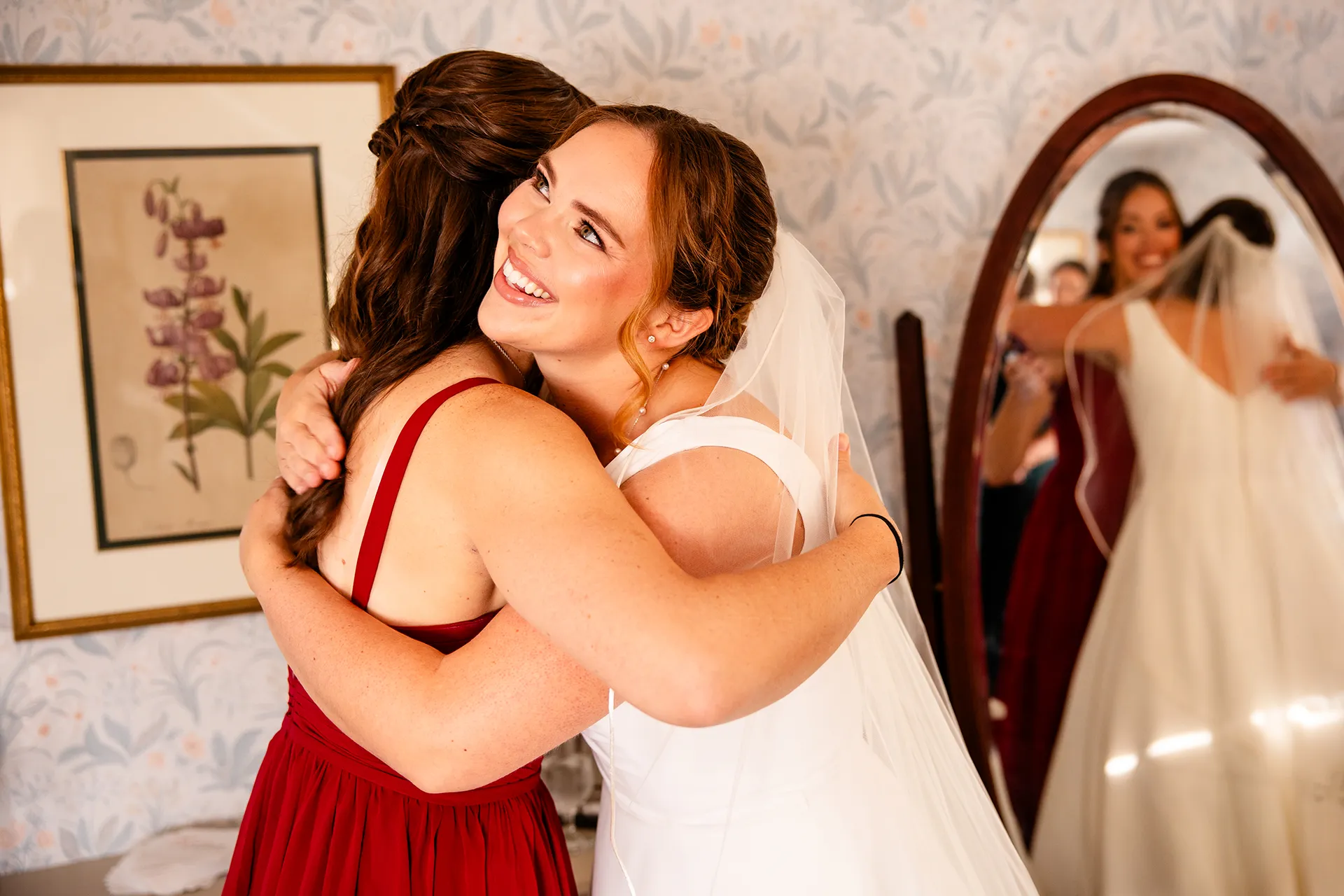 A bride hugs a bridesmaid as she sees her for the firsts time at Fruitlands Museum in Harvard Massachusetts.