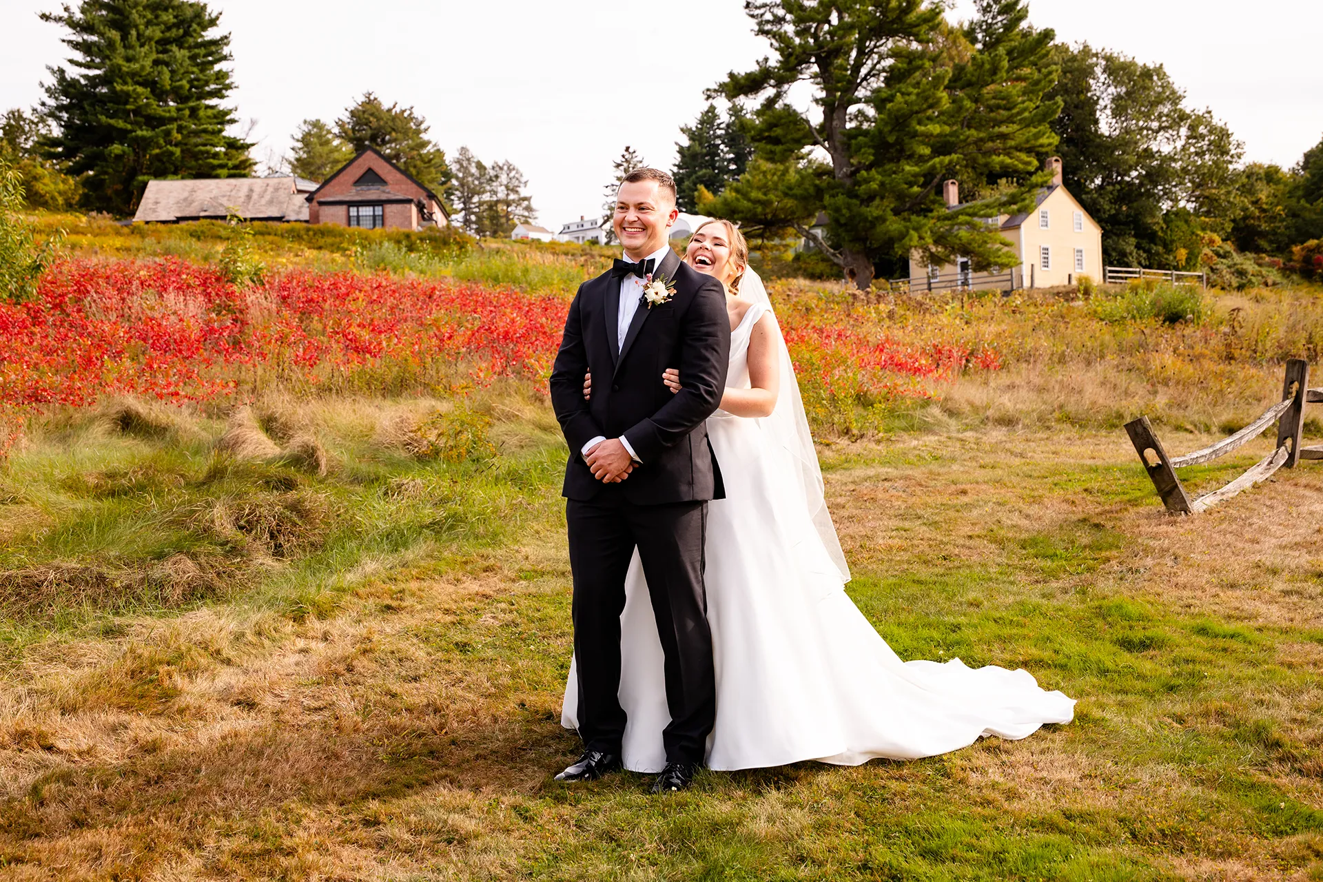 A laughing bride hugs a laughing groom during a first look at Fruitlands Museum in Harvard Massachusetts.