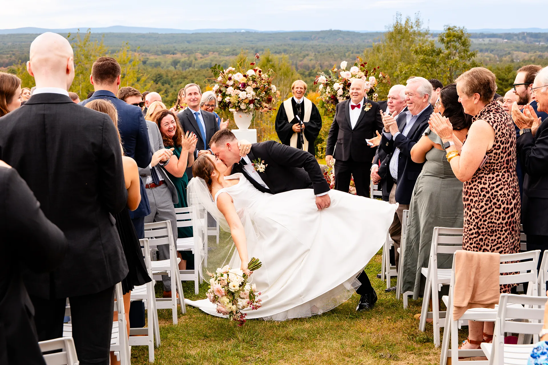 A groom dips a bride as they kiss during a wedding ceremony at Fruitlands Museum in Harvard Massachusetts.