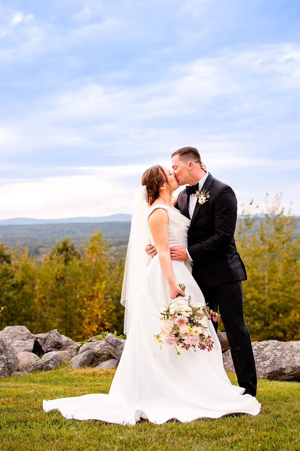 A newly married couple kiss during wedding portraits at Fruitlands Museum in Harvard, Massachusetts.