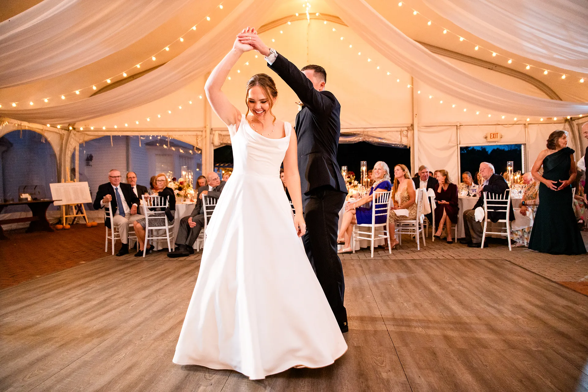 A groom spins a bride as they share a first dance during a wedding reception at Fruitlands Museum in Harvard, Massachusetts.