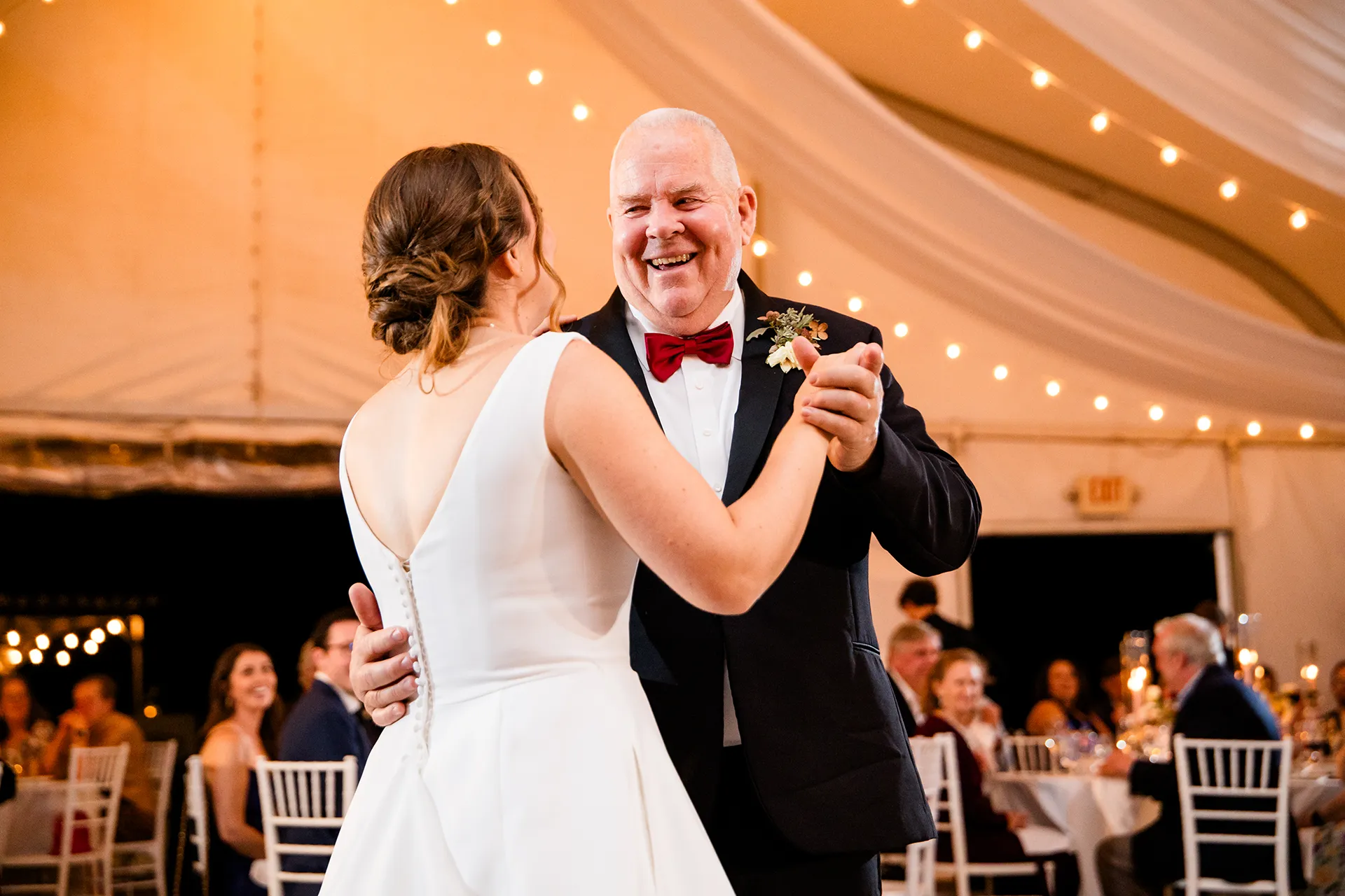 A dad laughs as he dances with a bride during a wedding reception at Fruitlands Museum in Harvard, Massachusetts.