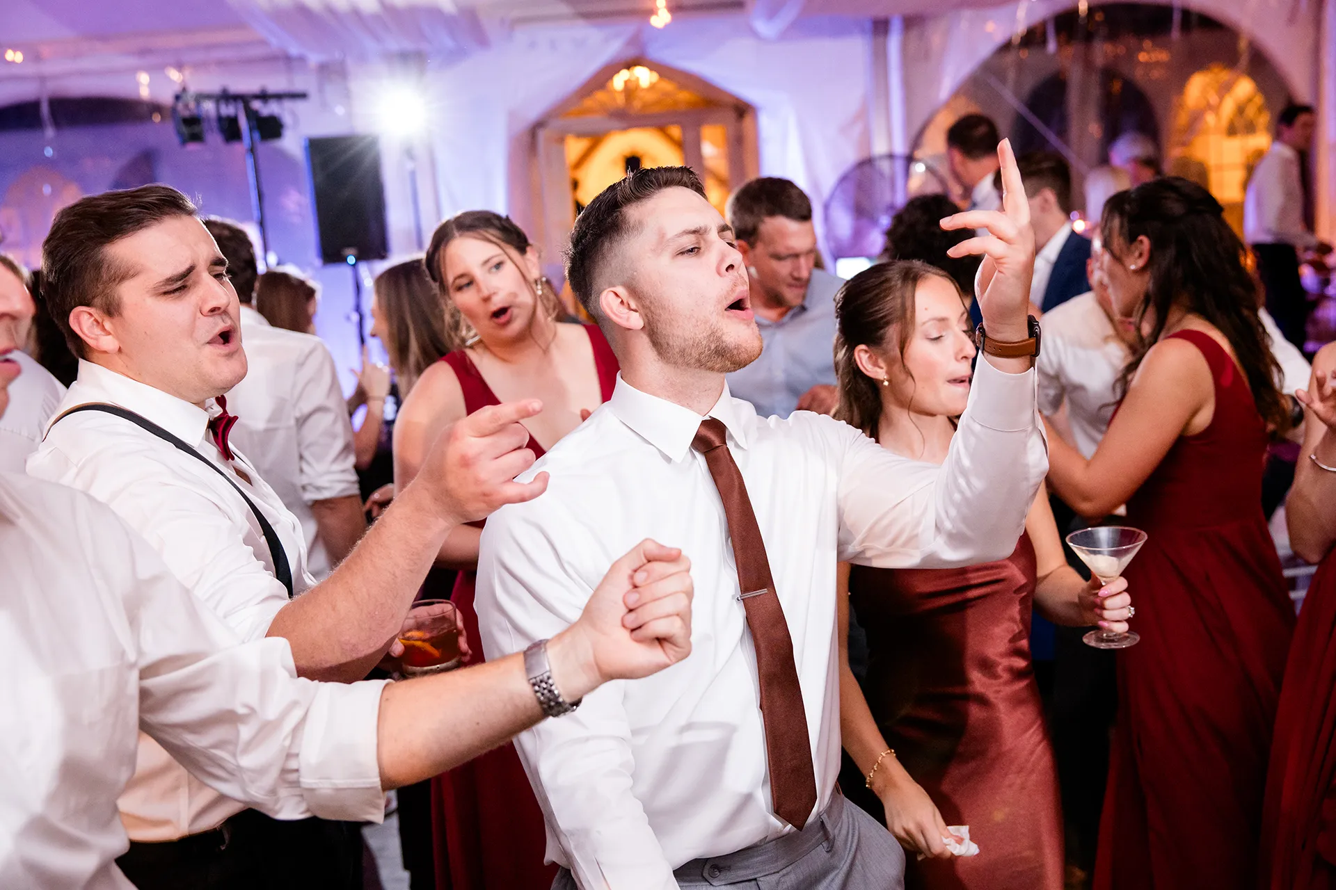 Guests sing as they dance during a wedding reception at Fruitlands Museum in Harvard, Massachusetts.