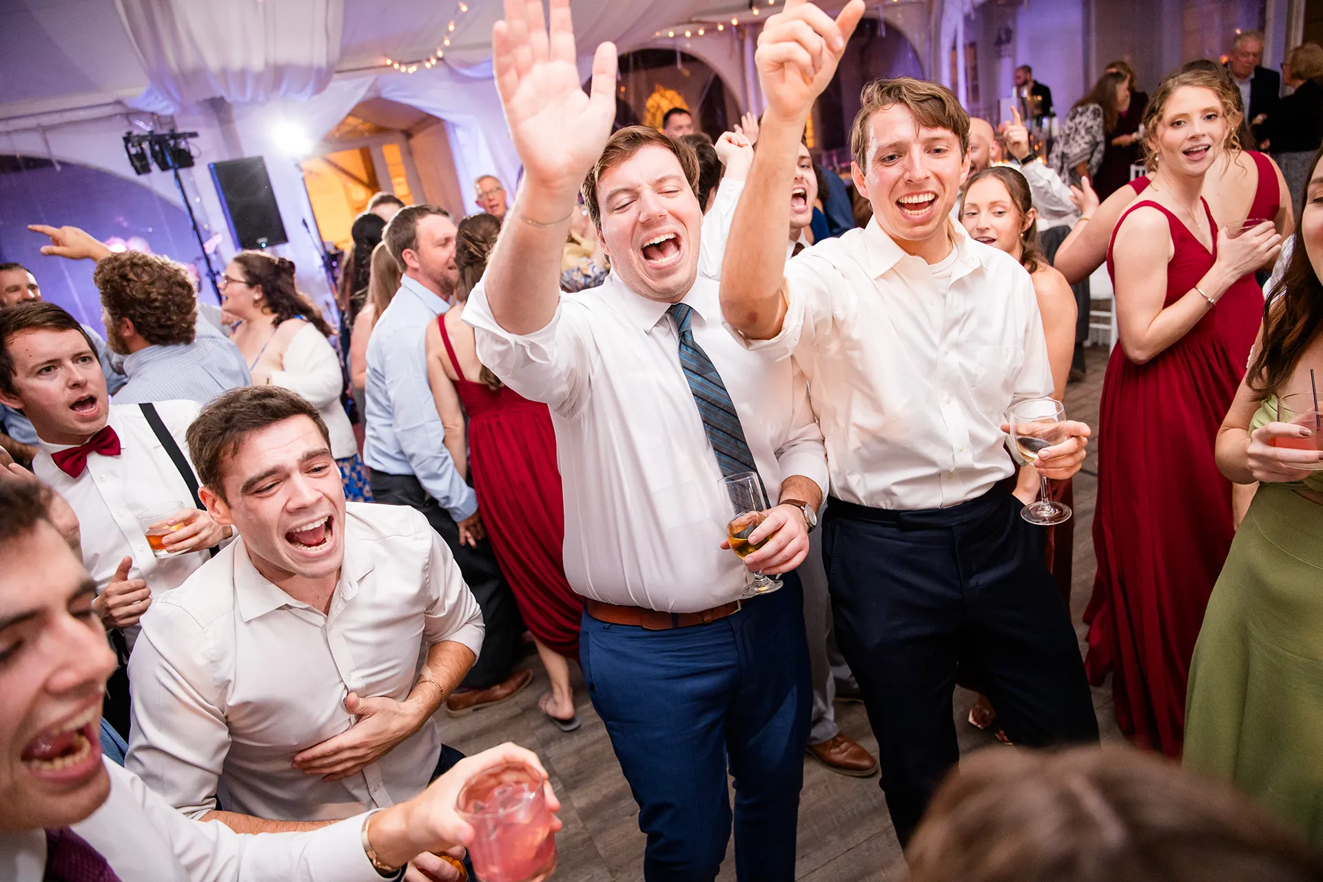 A bunch of men sing while they dance during a wedding reception at Fruitlands Museum in Harvard, Massachusetts.