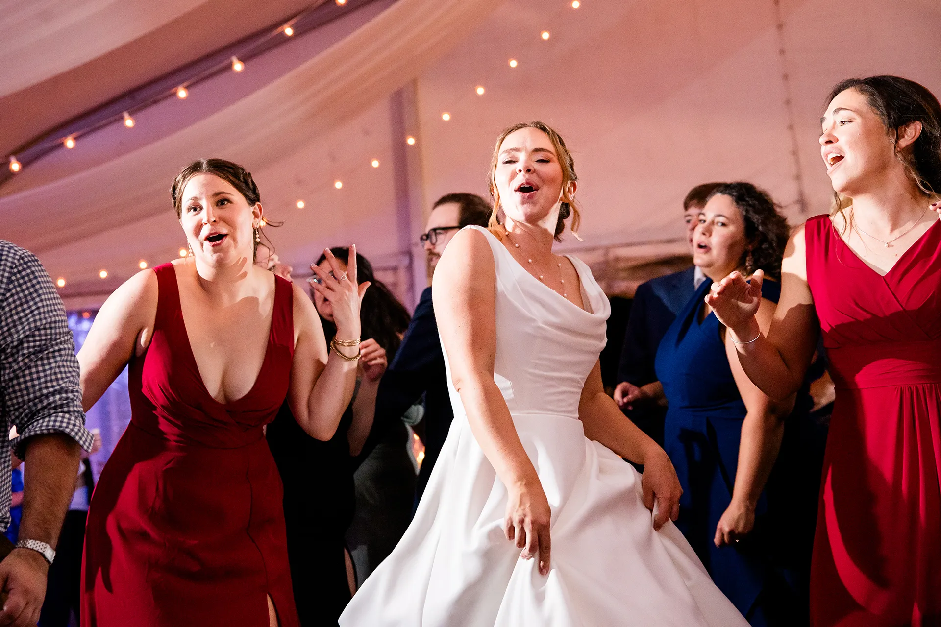 A bride dances with bridesmaids during a wedding reception at Fruitlands Museum in Harvard, Massachusetts.