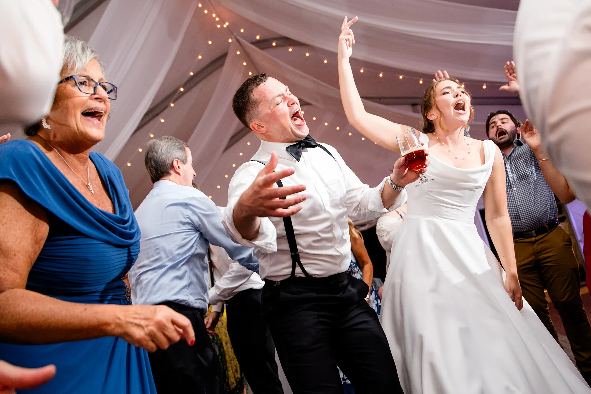 A bride and groom dance with guests during a wedding reception at Fruitlands Museum in Harvard, Massachusetts.