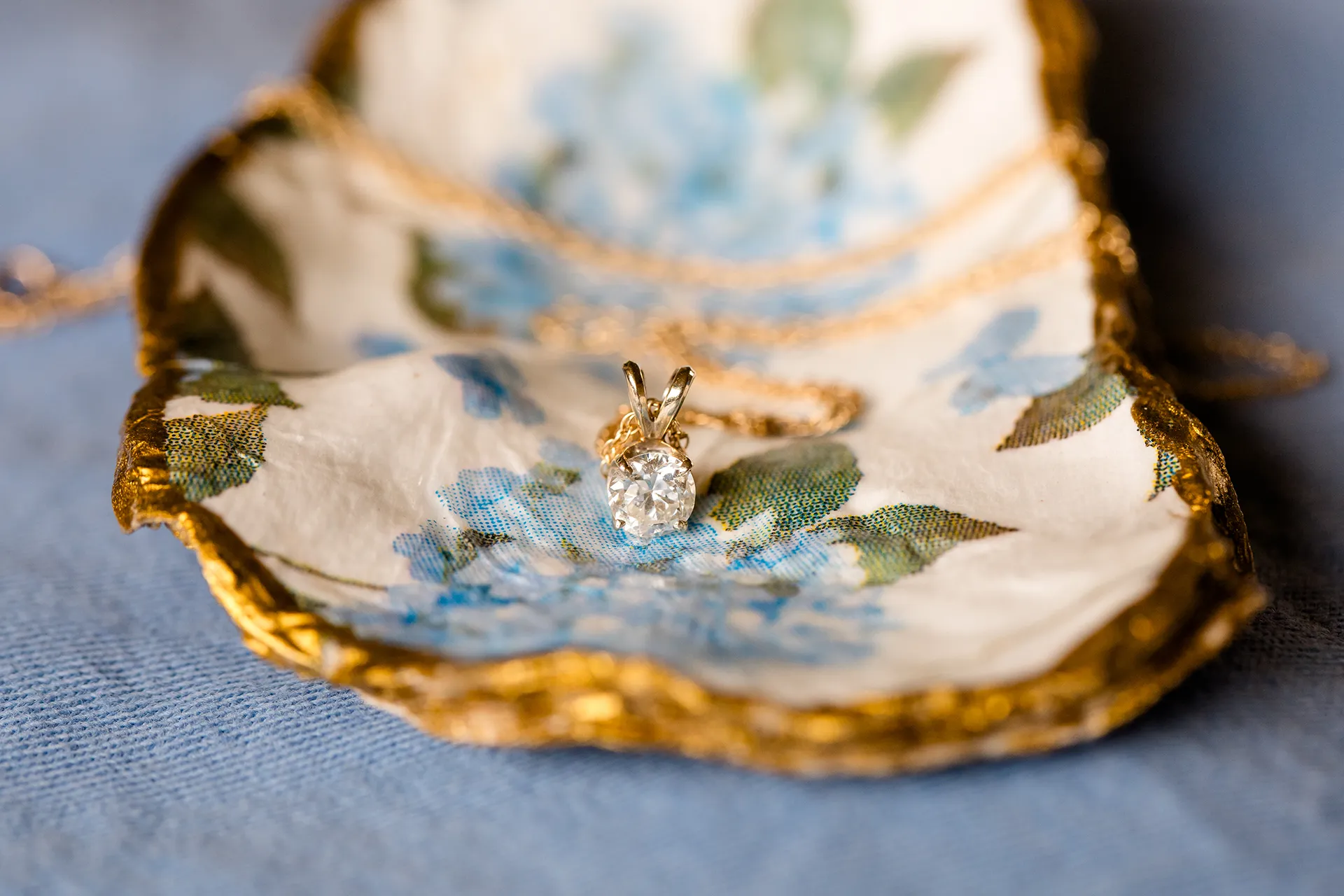 maine wedding photography meghan phil 02 A closeup of a diamond necklace with gold chain at the Atlantic Oceanside Hotel and Event Center in Bar Harbor, Maine.