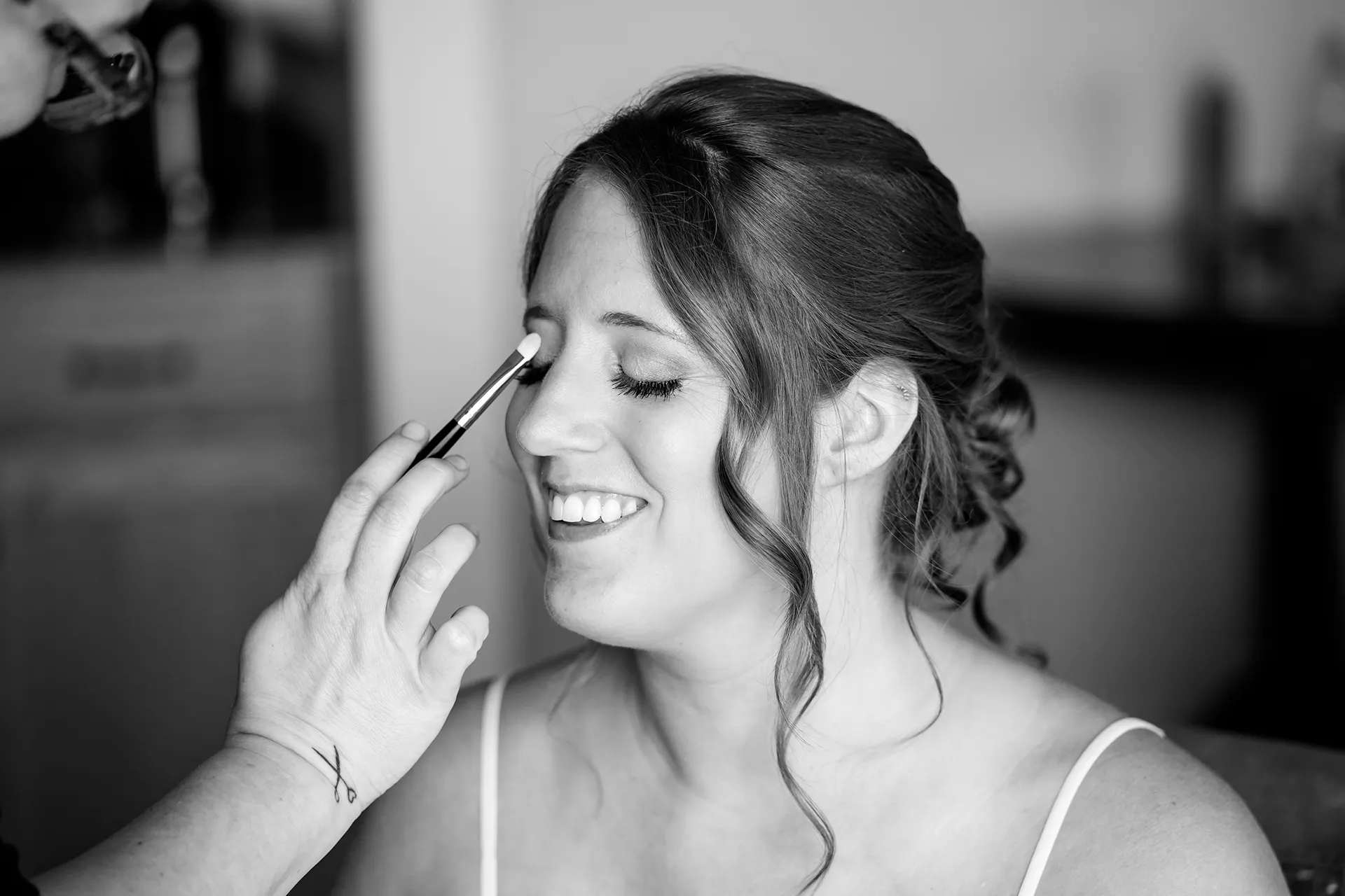 maine wedding photography meghan phil 05 A bride smiles as she gets her makeup done for her wedding at the Atlantic Oceanside Hotel and Event Center in Bar Harbor, Maine.
