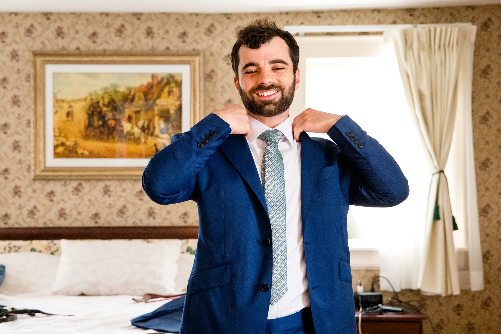 maine wedding photography meghan phil 17 A groom smiles as he puts on his jacket for his wedding at the Atlantic Oceanside Hotel and Event Center in Bar Harbor, Maine.