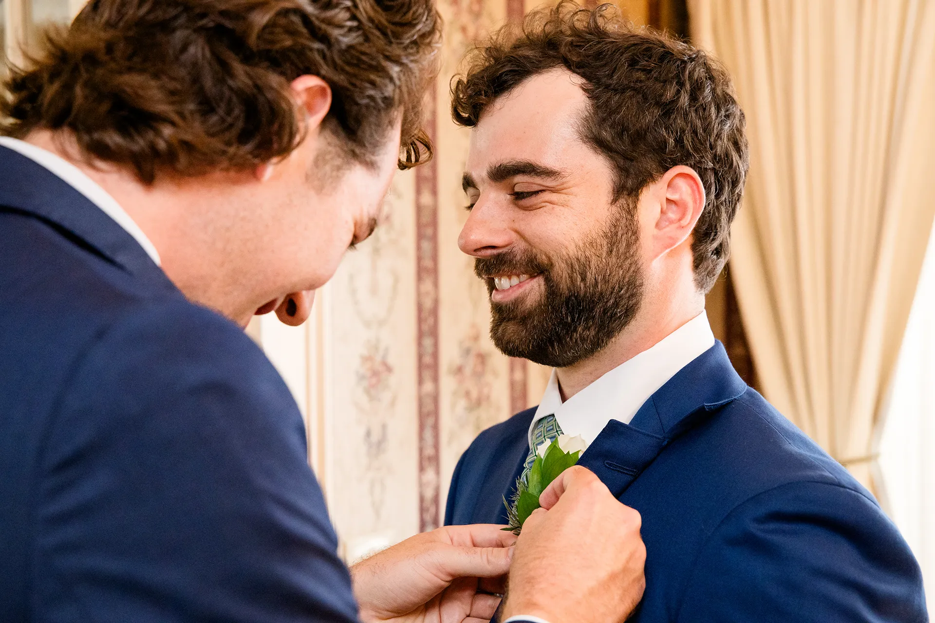maine wedding photography meghan phil 18 A groomsman put on a groom's boutonniere he gets ready for a wedding at the Atlantic Oceanside Hotel and Event Center in Bar Harbor, Maine.