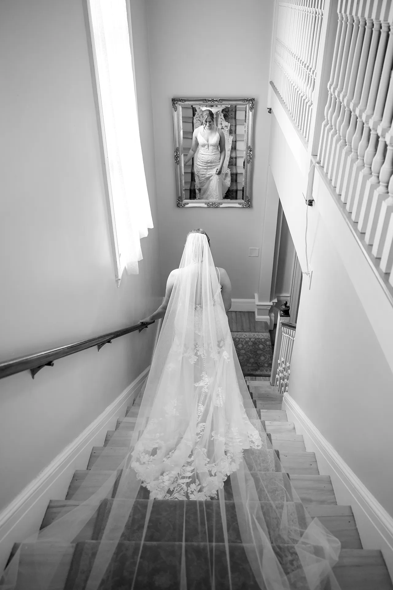 maine wedding photography meghan phil 19 A bride is reflected in a mirror as she walks down the stairs at the Willows on the property of the Atlantic Oceanside Hotel & Event Center in Bar Harbor, Maine.