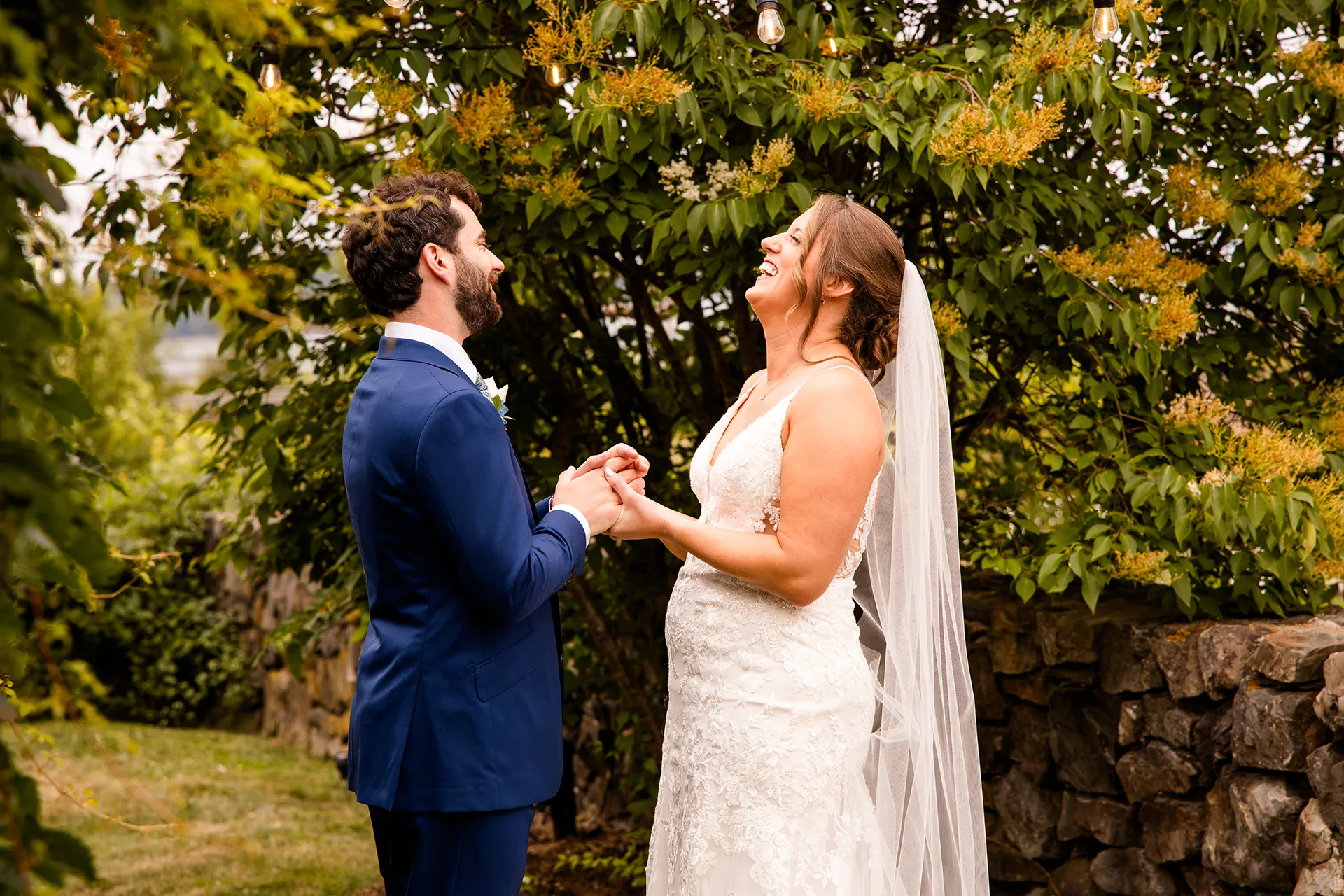 maine wedding photography meghan phil 22 A bride and groom hold hands and laugh during a first look in the garden at the Atlantic Oceanside Hotel & Event Center in Bar Harbor, Maine.